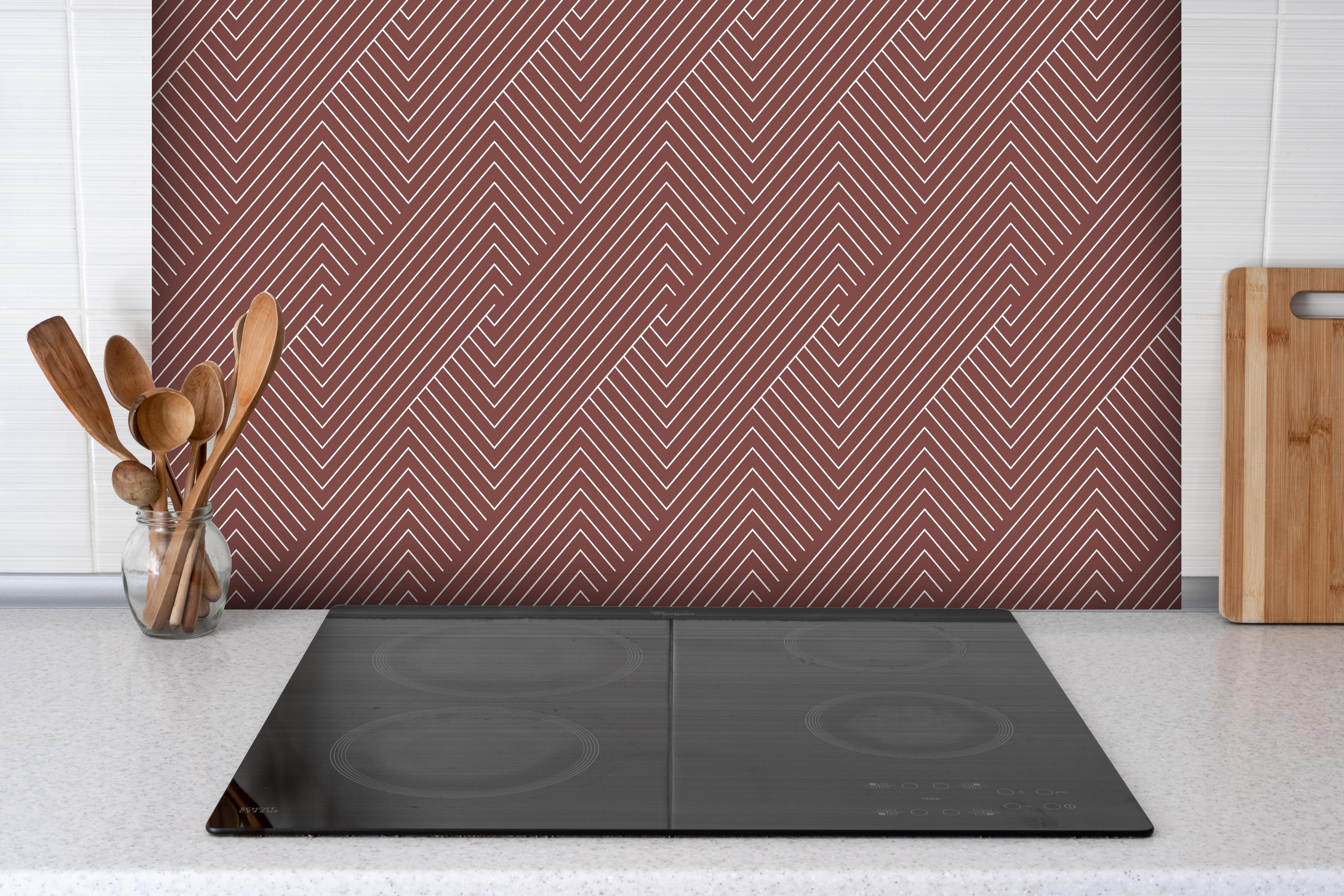 Spritzschutz - Geometrica Intreccio Mattone hinter einem Cerankochfeld zwischen Holz-Kochutensilien