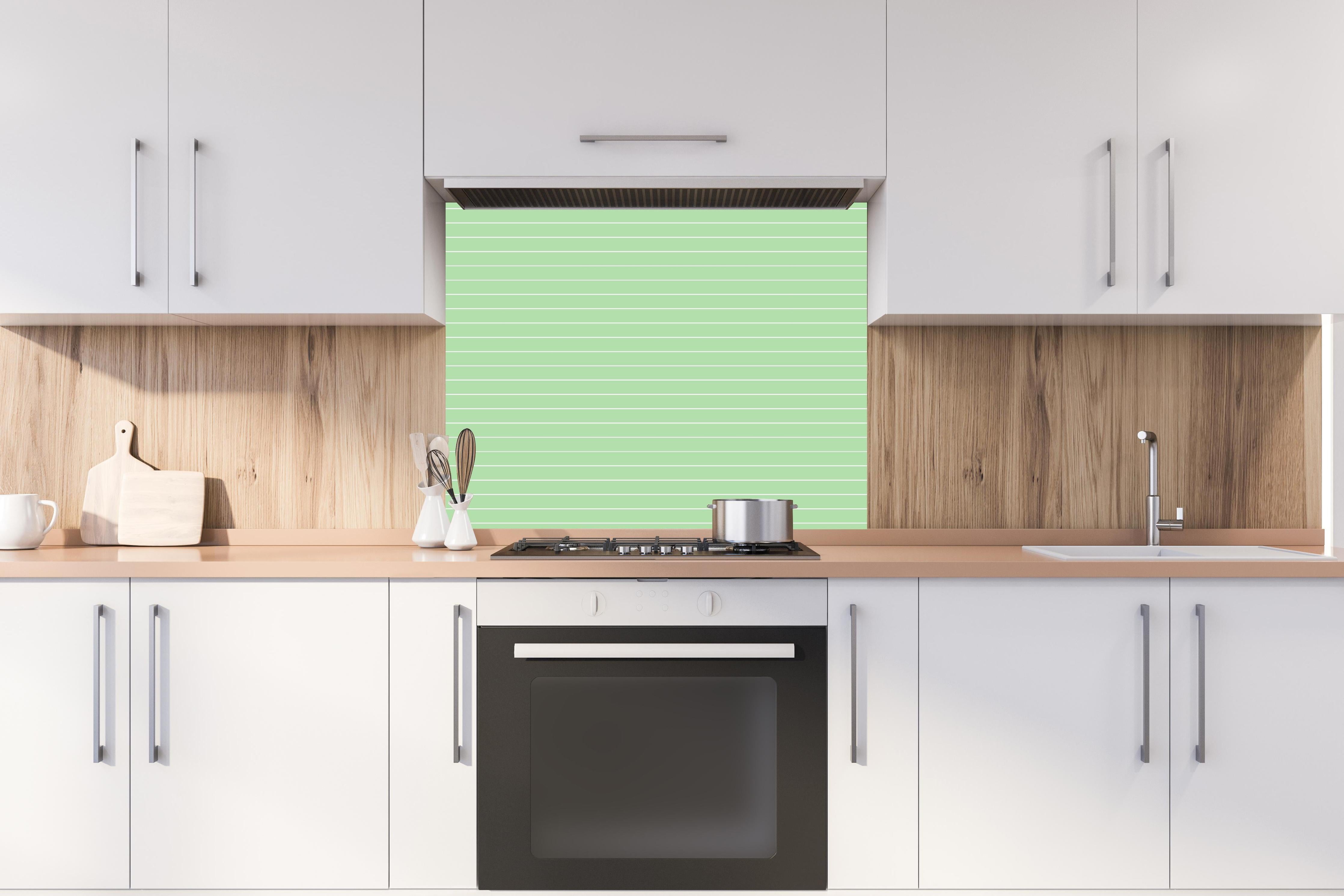 Spritzschutz - Geometrica Orizzontale Muschio hinter einem Cerankochfeld zwischen Holz-Kochutensilien