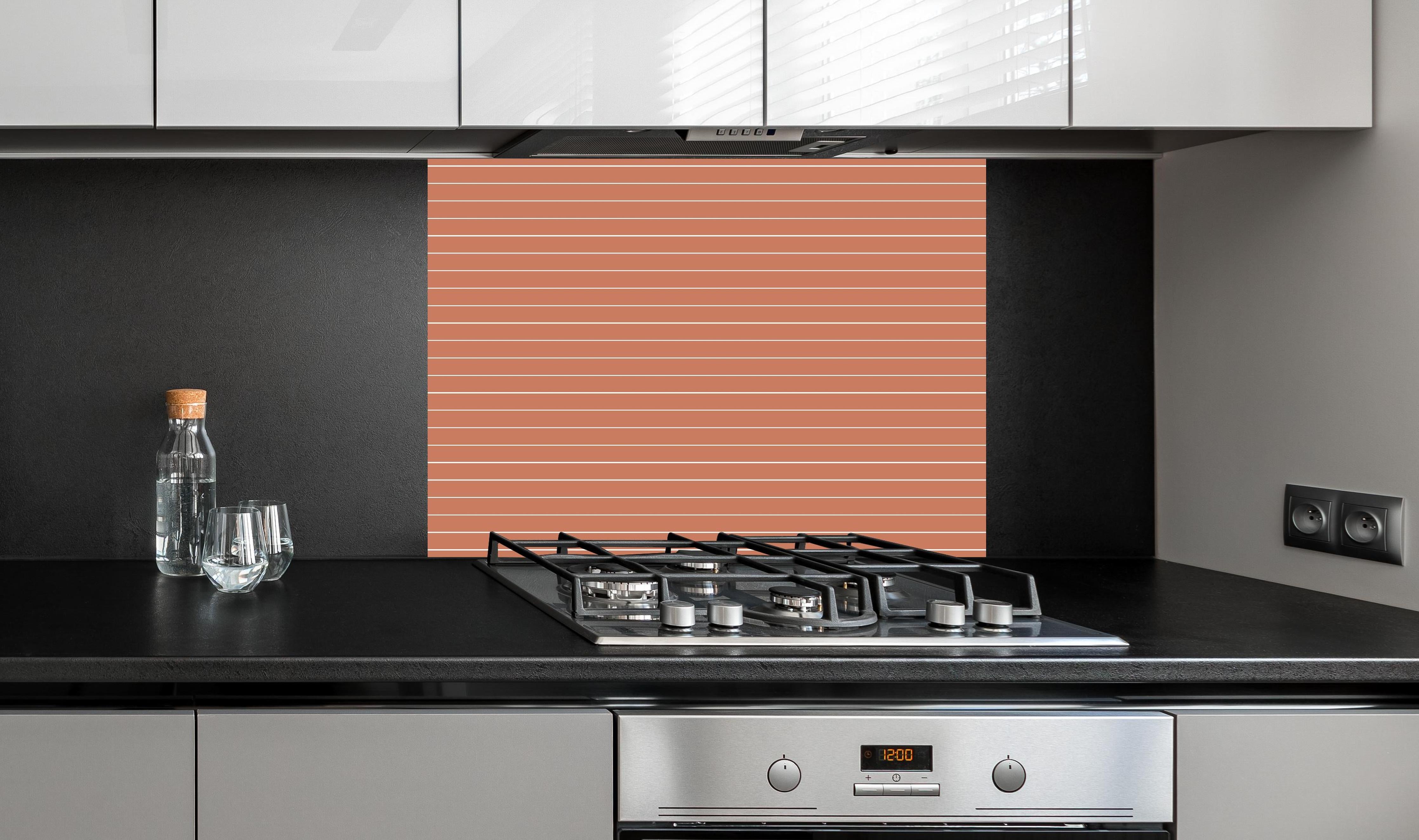 Spritzschutz - Geometrica Orizzontale Terracotta hinter einem Cerankochfeld zwischen Holz-Kochutensilien