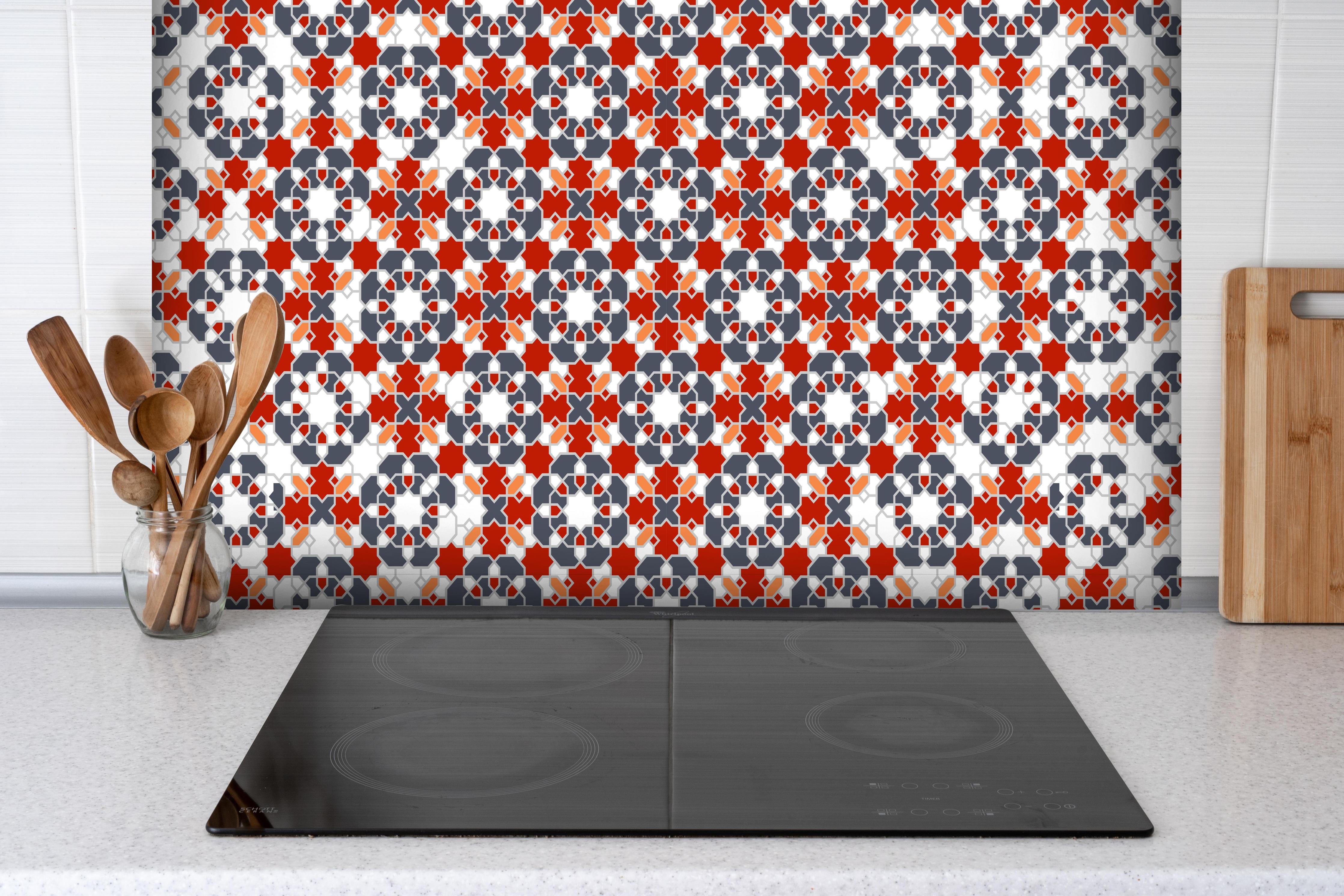 Spritzschutz - Geometrische Fliesen hinter einem Cerankochfeld zwischen Holz-Kochutensilien