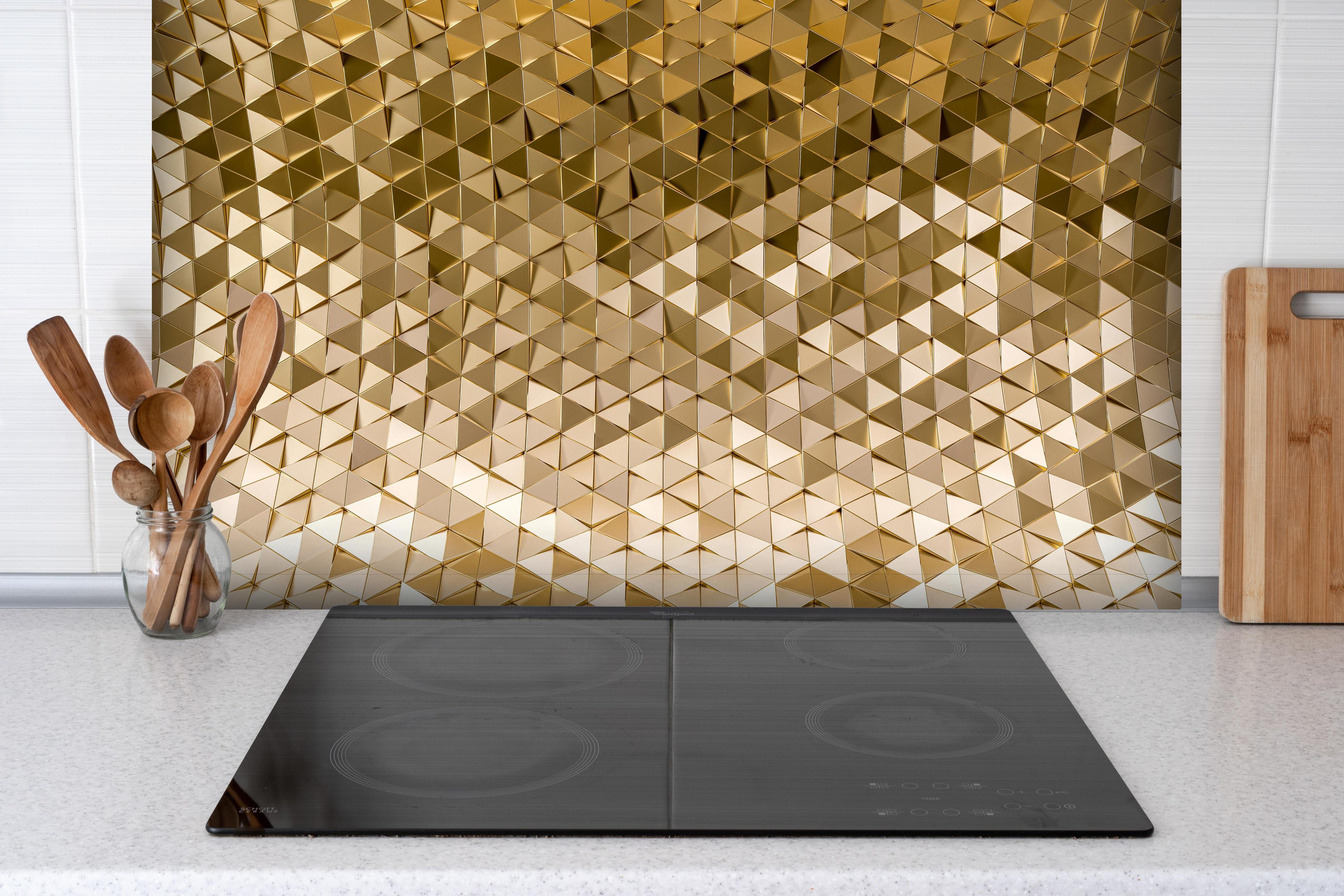 Spritzschutz - Geometrisches Gold-Dreieck-Kurvenmuster hinter einem Cerankochfeld zwischen Holz-Kochutensilien