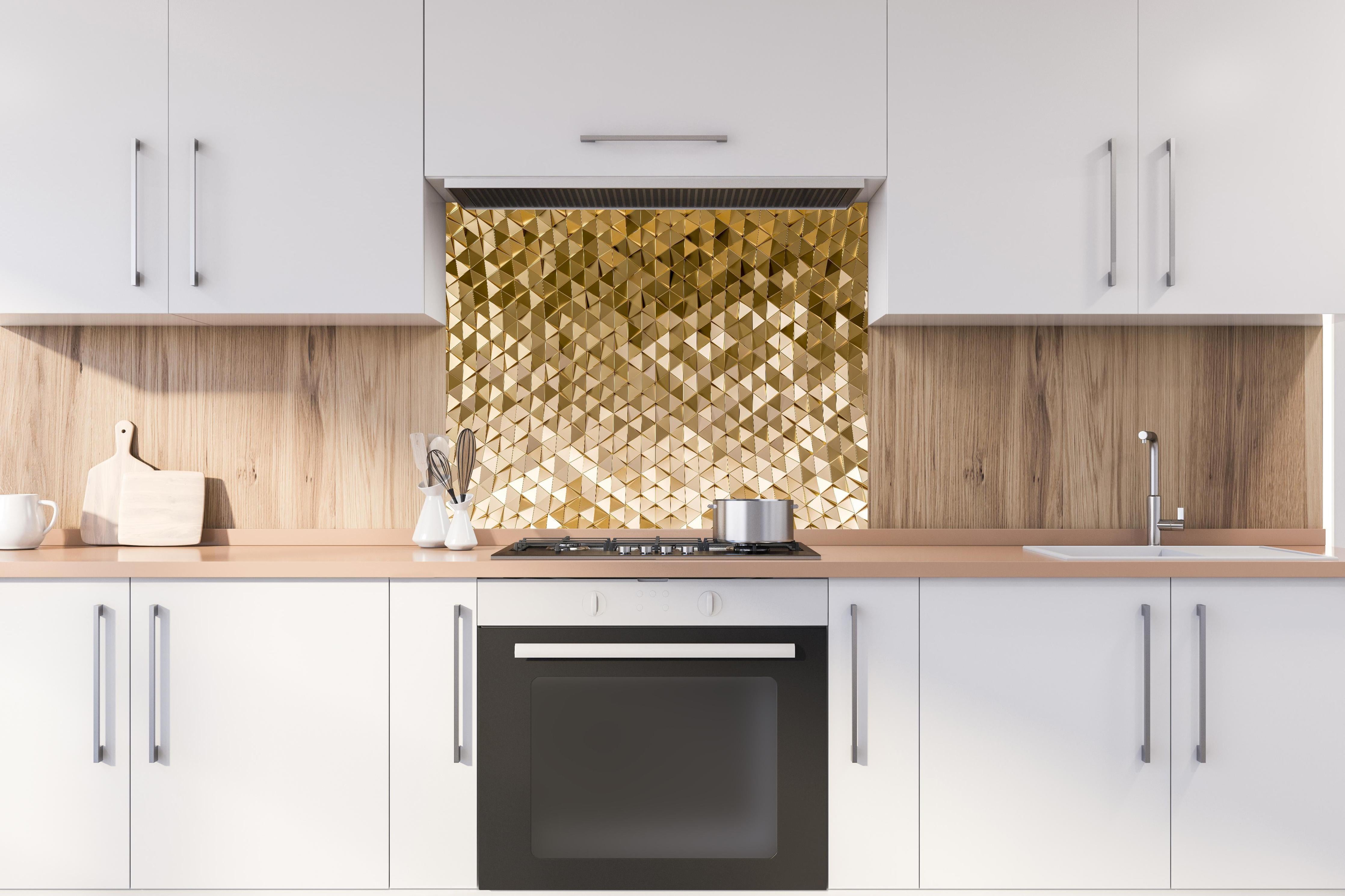 Spritzschutz - Geometrisches Gold-Dreieck-Kurvenmuster hinter einem Cerankochfeld zwischen Holz-Kochutensilien