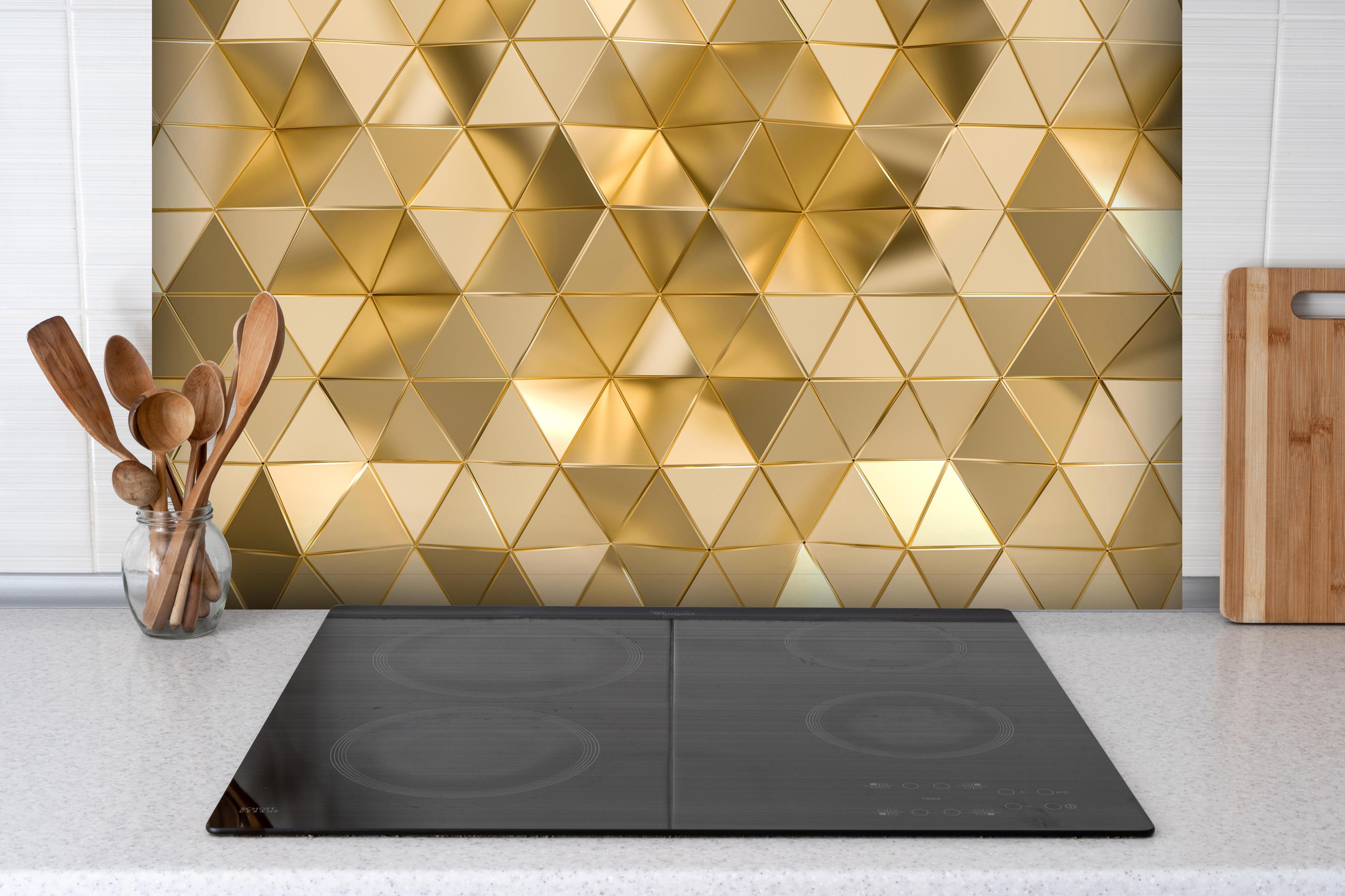 Spritzschutz - Geometrisches Gold Dreieck Polygon-Design hinter einem Cerankochfeld zwischen Holz-Kochutensilien
