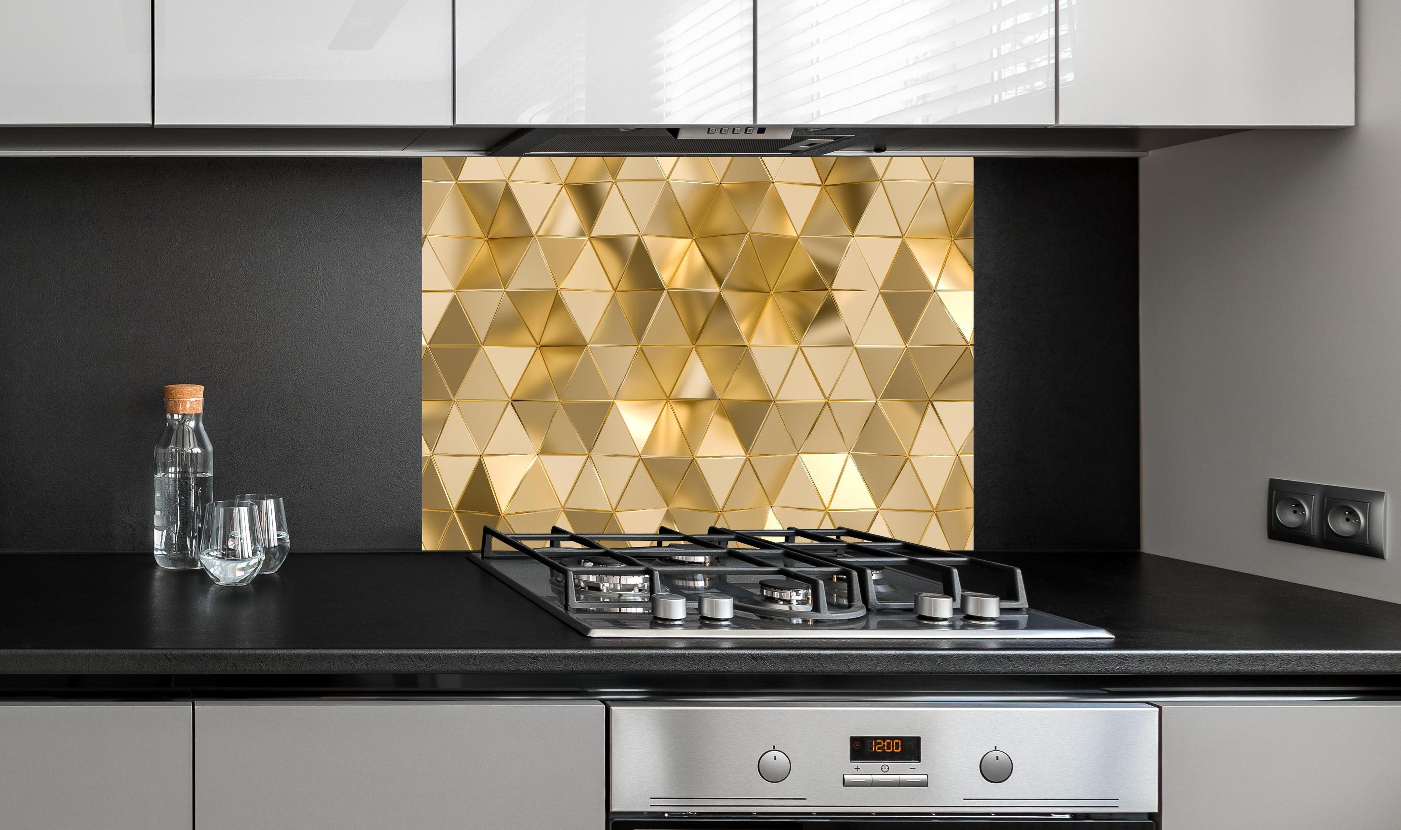 Spritzschutz - Geometrisches Gold Dreieck Polygon-Design hinter einem Cerankochfeld zwischen Holz-Kochutensilien