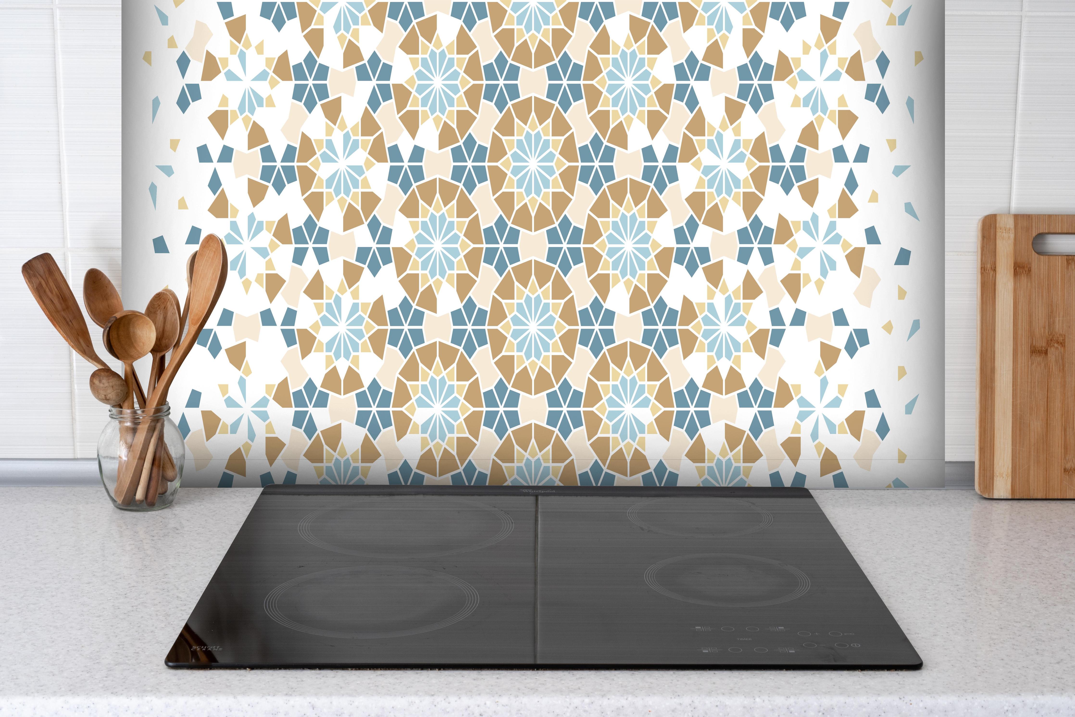 Spritzschutz - Geometrisches Mosaik-Design in Pastelltönen hinter einem Cerankochfeld zwischen Holz-Kochutensilien