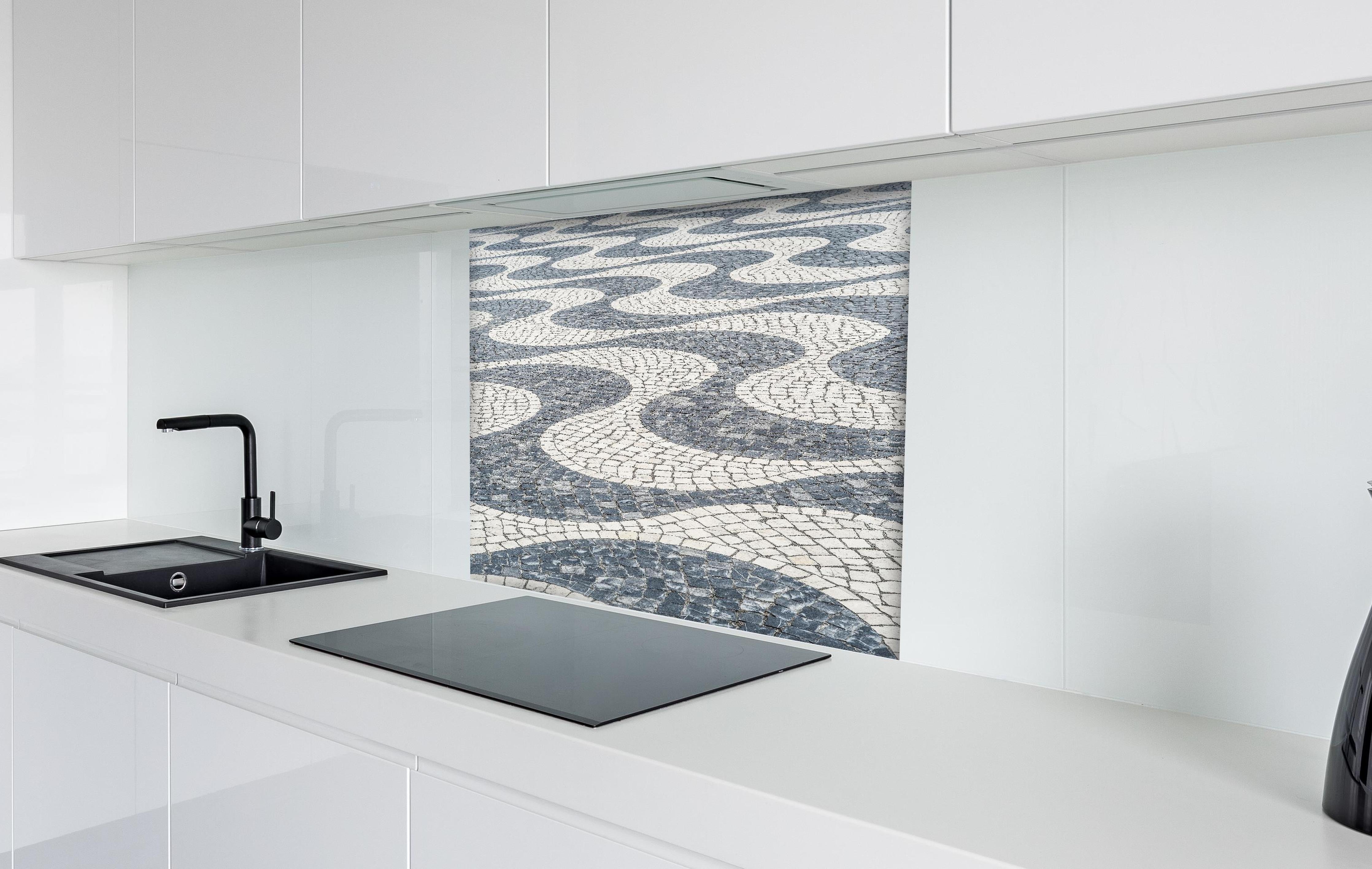 Spritzschutz - Geometrisches Mosaikmuster in Schwarz-Weiß hinter einem Cerankochfeld zwischen Holz-Kochutensilien