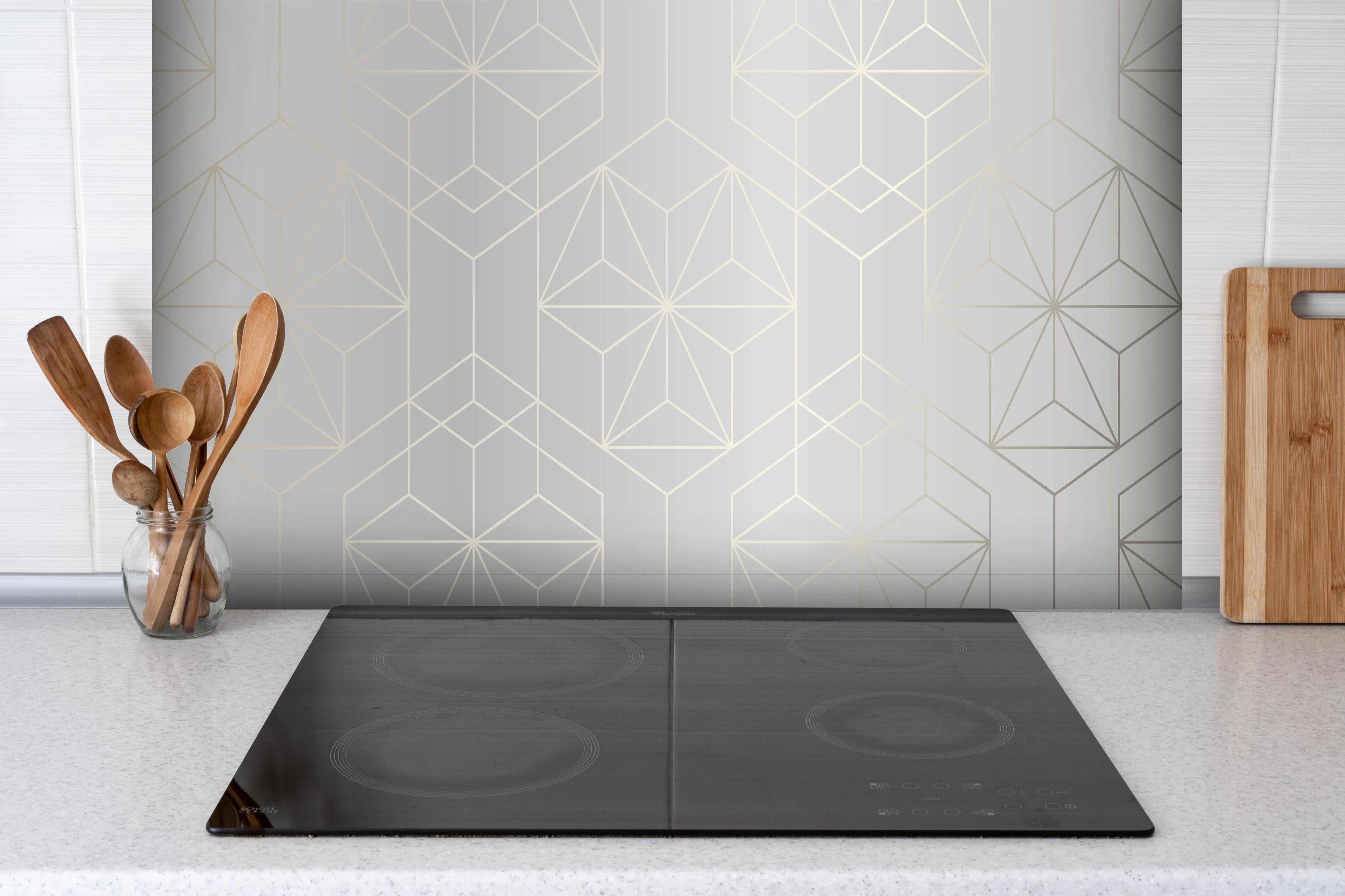 Spritzschutz - Geometrisches Muster Weiß und Grau hinter einem Cerankochfeld zwischen Holz-Kochutensilien