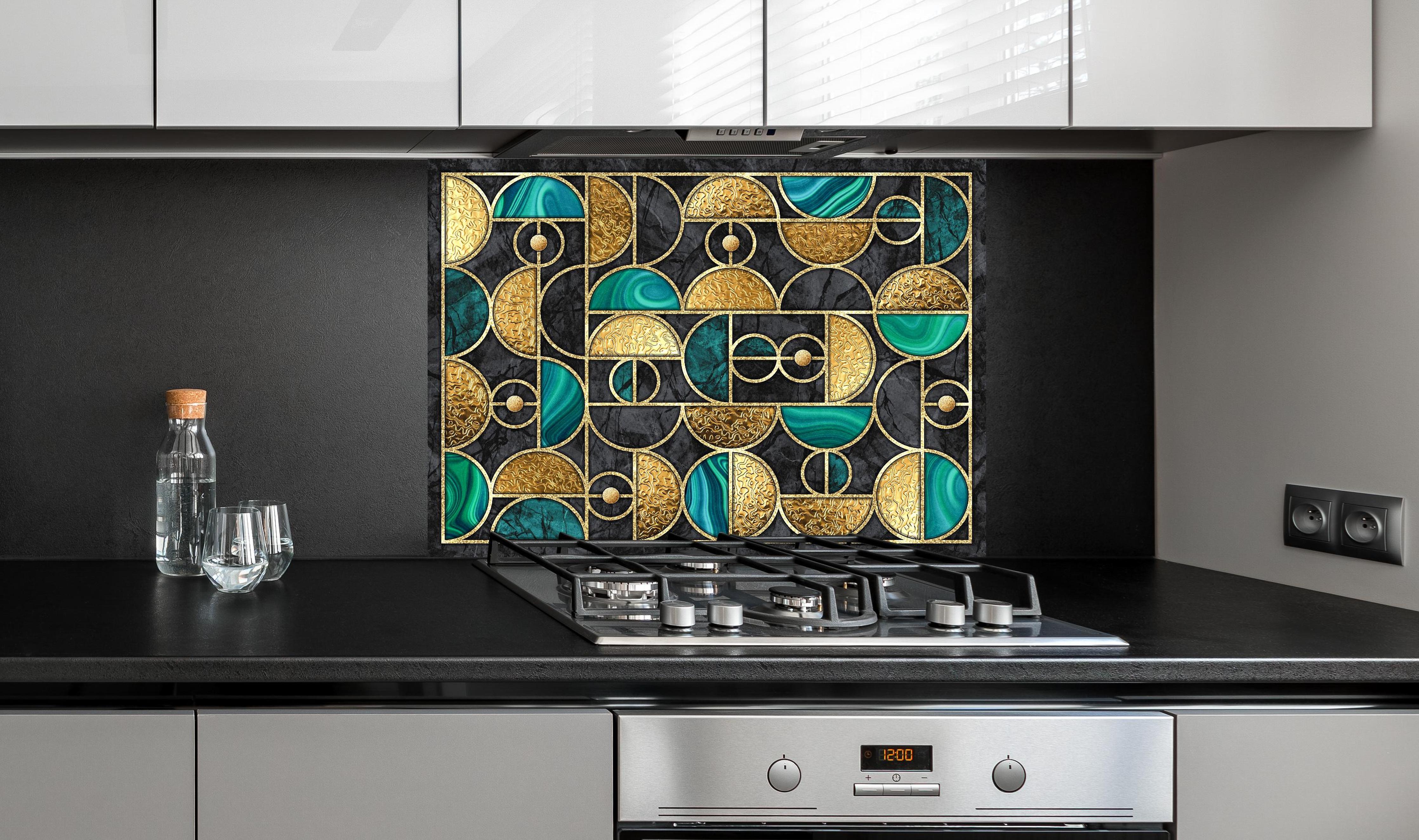 Spritzschutz - Geometrisches Schwarz-Gold-Grün Ringmosaik hinter einem Cerankochfeld zwischen Holz-Kochutensilien