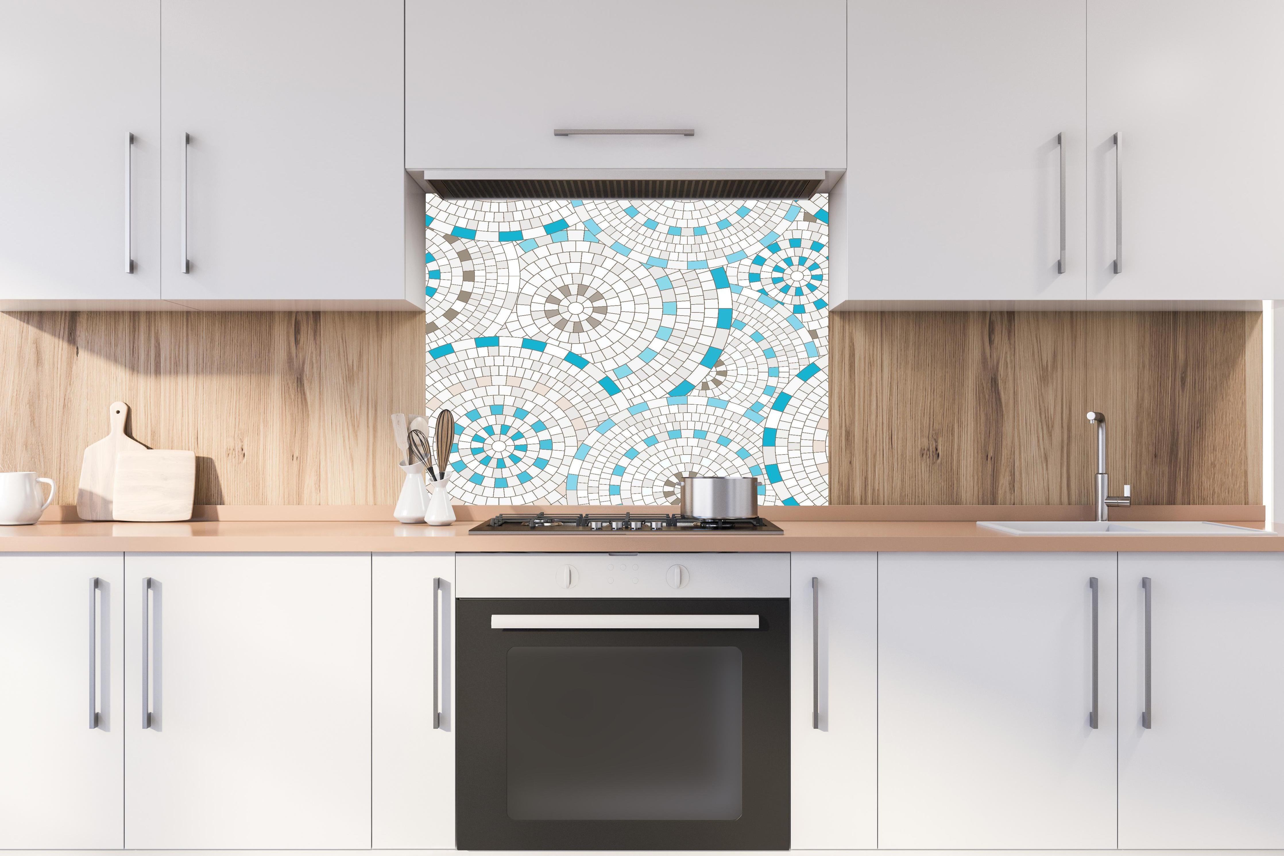 Spritzschutz - Geometrisches Weiß-Blau Mosaik Fliesenmuster hinter einem Cerankochfeld zwischen Holz-Kochutensilien
