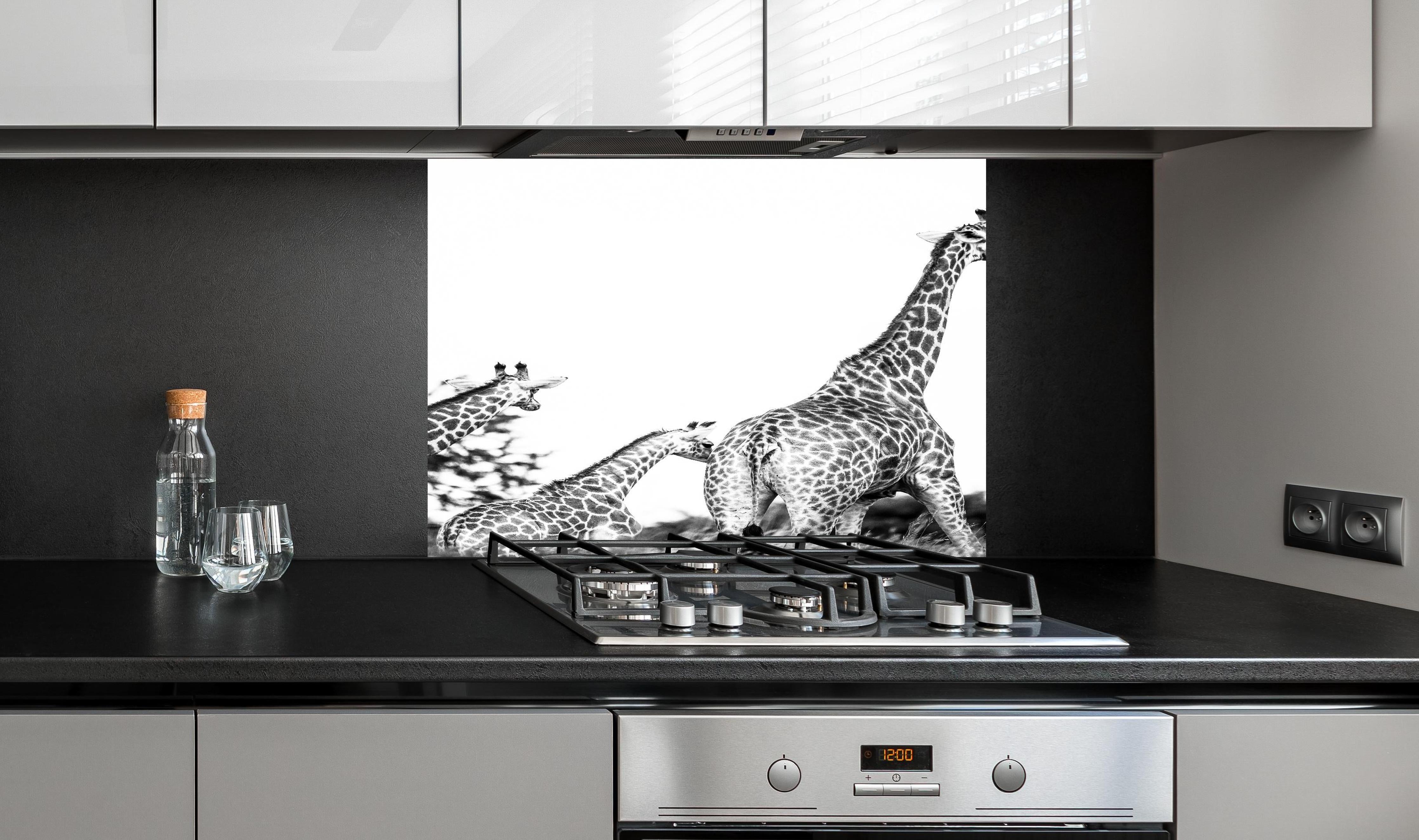 Spritzschutz - Giraffen Familie - schwarz-weiß hinter einem Cerankochfeld zwischen Holz-Kochutensilien