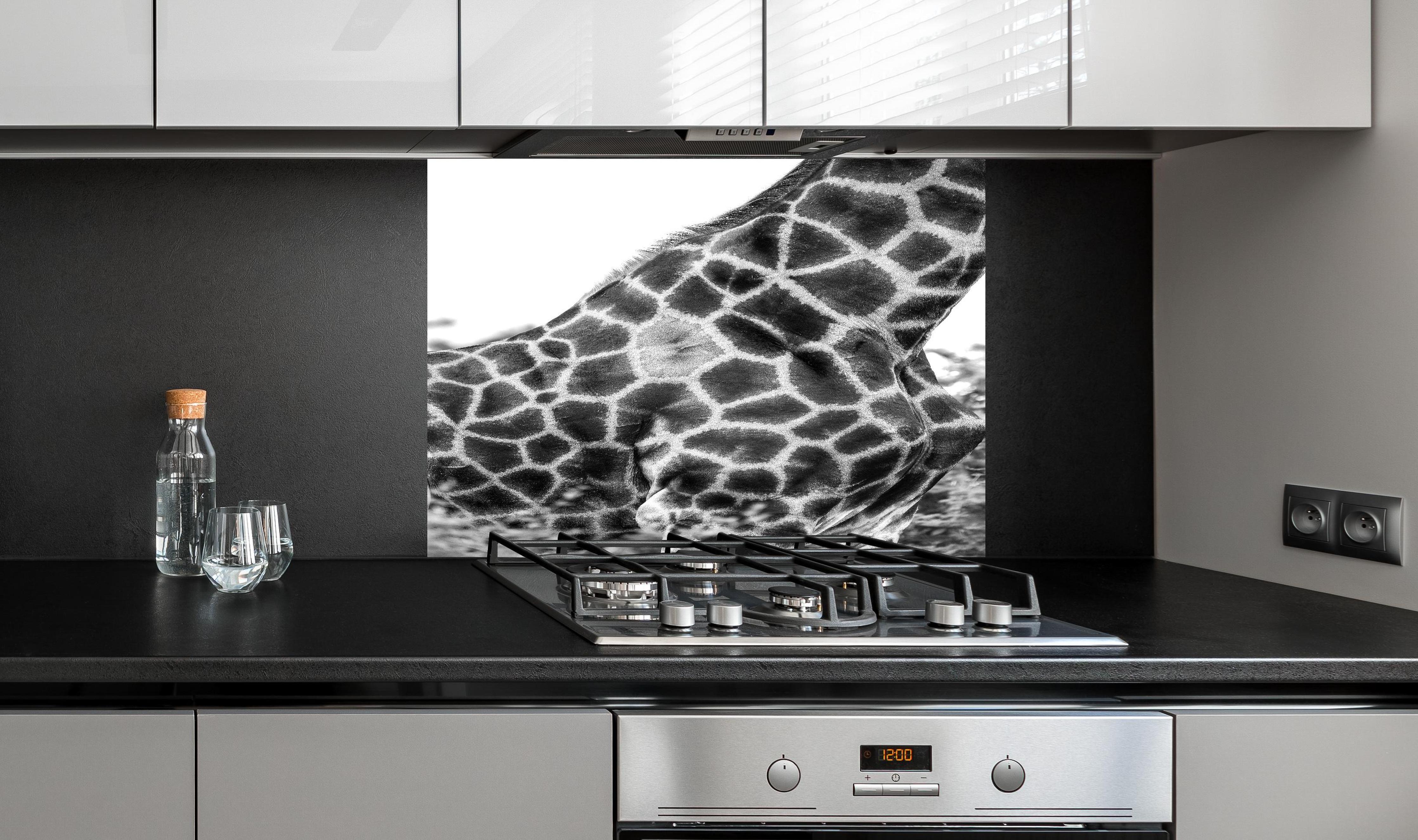 Spritzschutz - Giraffen Oberkörper hinter einem Cerankochfeld zwischen Holz-Kochutensilien