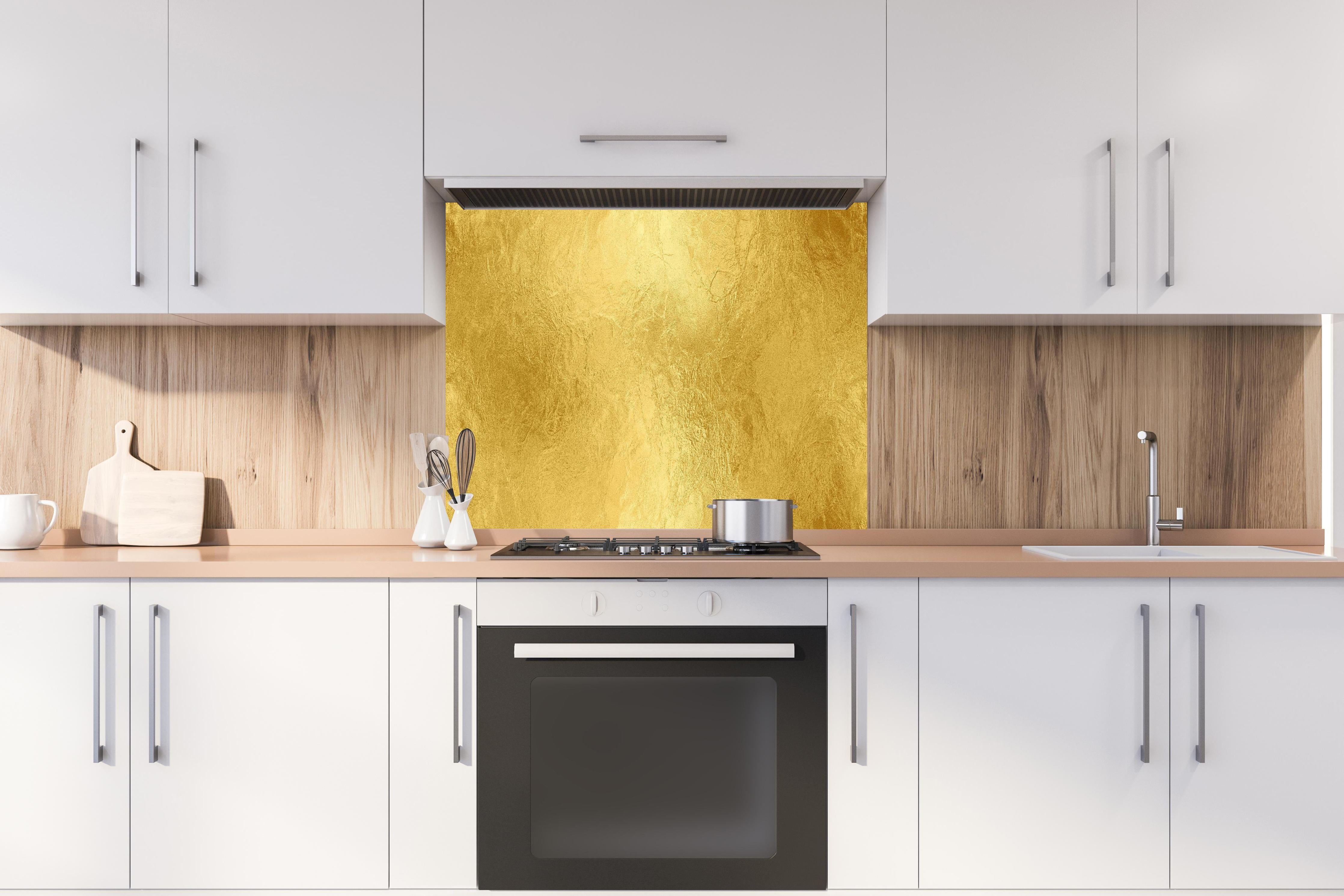 Spritzschutz - Glänzende Blattgold Textur hinter einem Cerankochfeld zwischen Holz-Kochutensilien