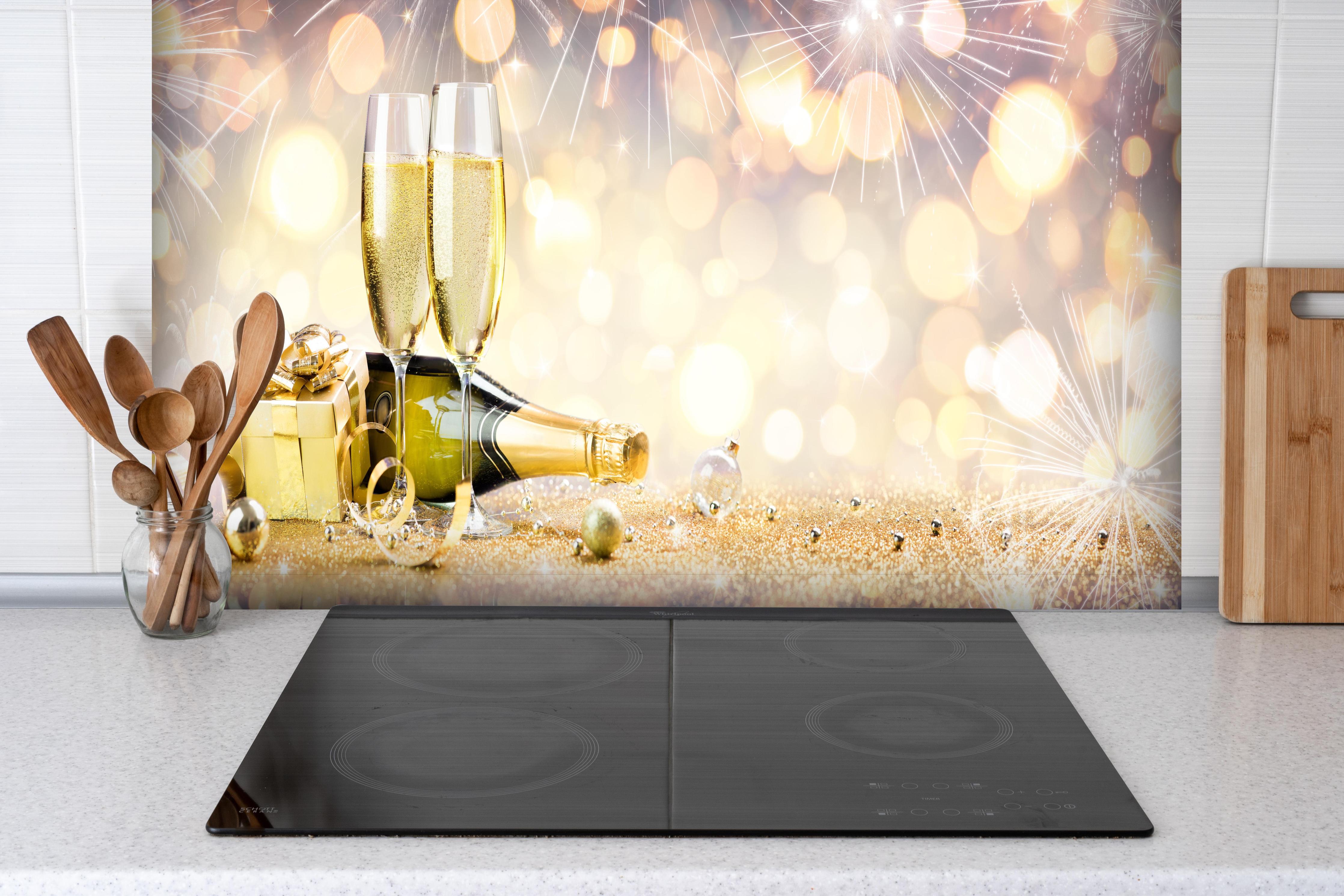 Spritzschutz - Glamouröse Gold-Champagner-Feier hinter einem Cerankochfeld zwischen Holz-Kochutensilien