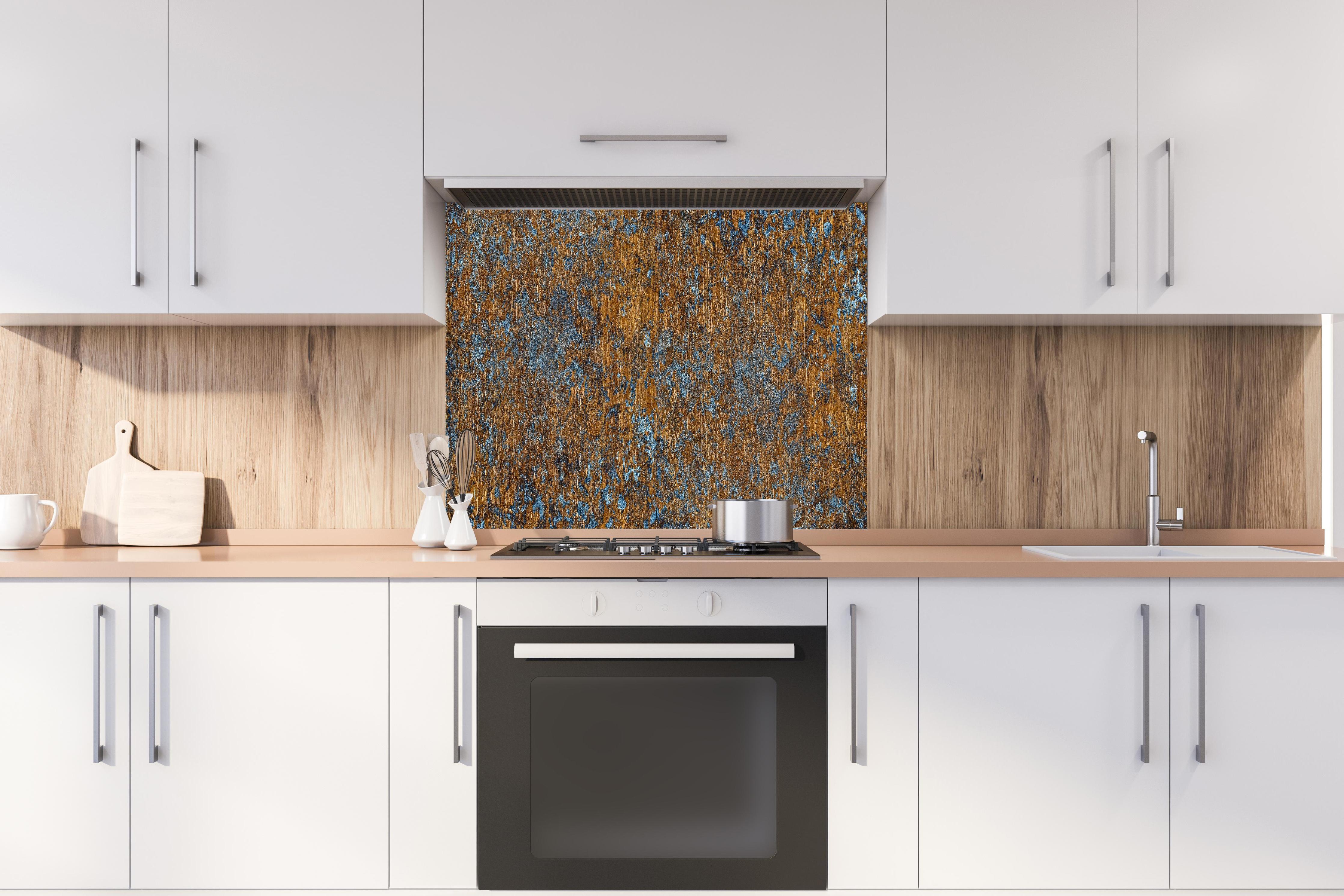 Spritzschutz - Gold-blaue alte Metalltextur hinter einem Cerankochfeld zwischen Holz-Kochutensilien