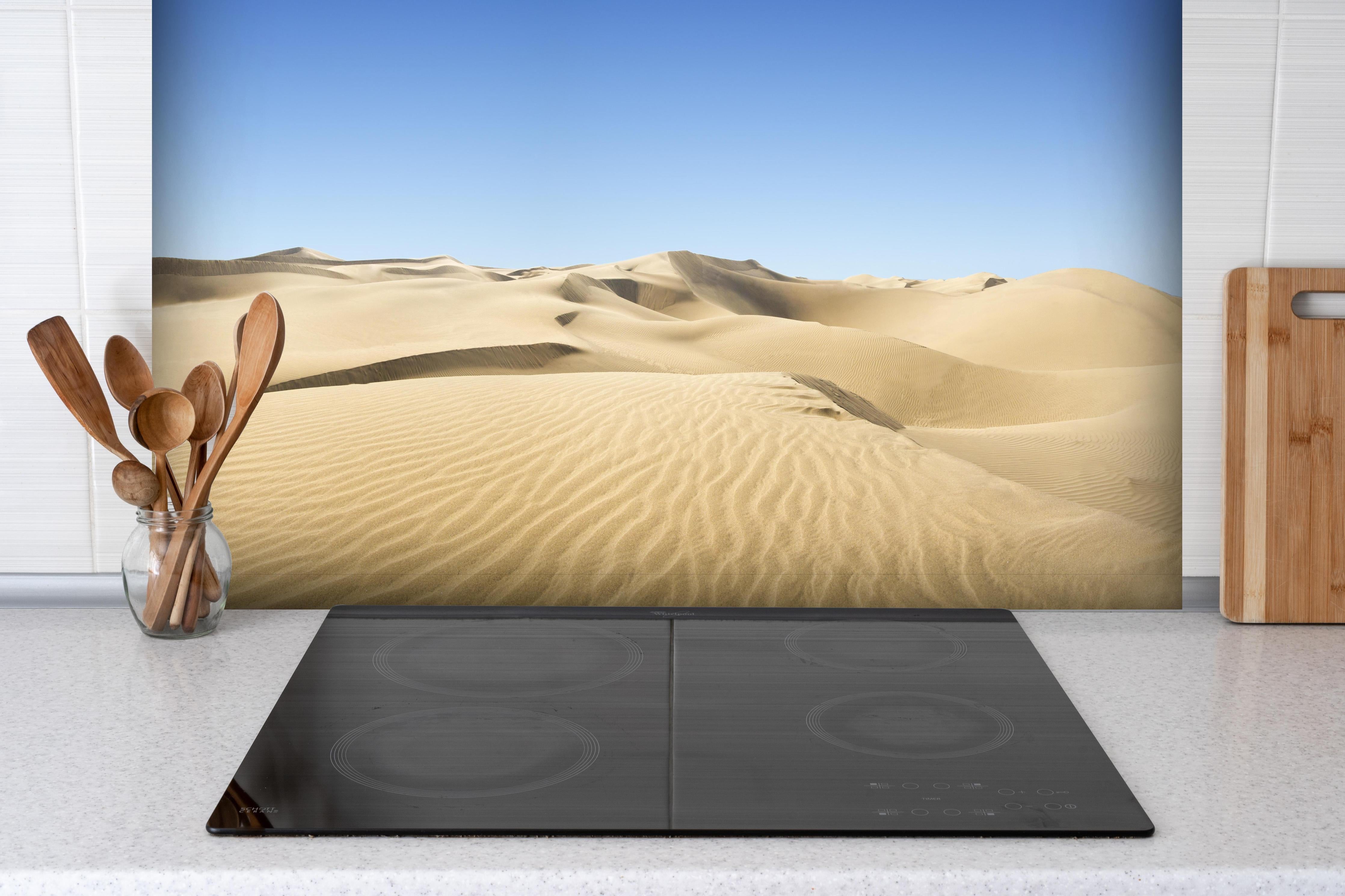 Spritzschutz - Gold desert hinter einem Cerankochfeld zwischen Holz-Kochutensilien