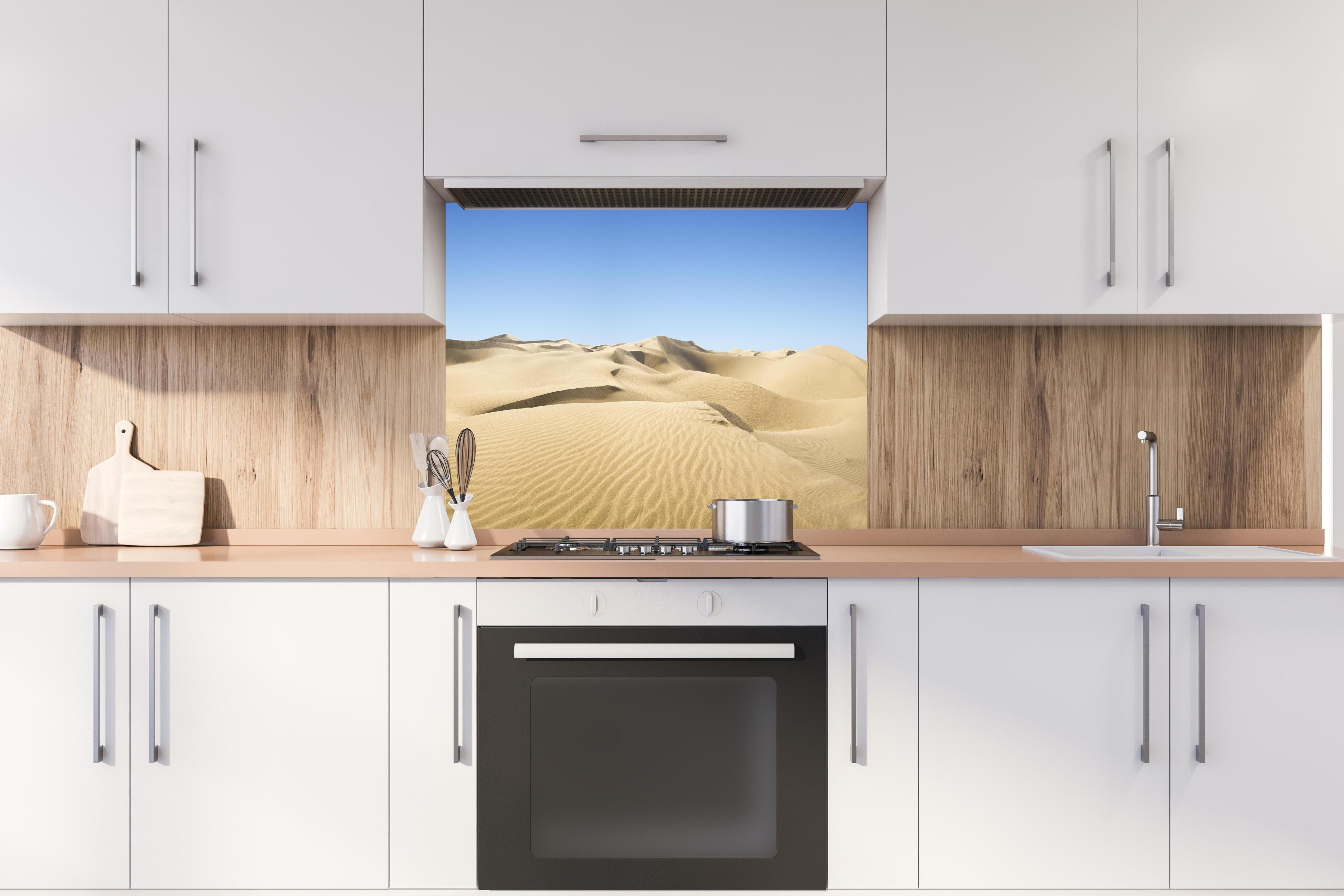 Spritzschutz - Gold desert hinter einem Cerankochfeld zwischen Holz-Kochutensilien