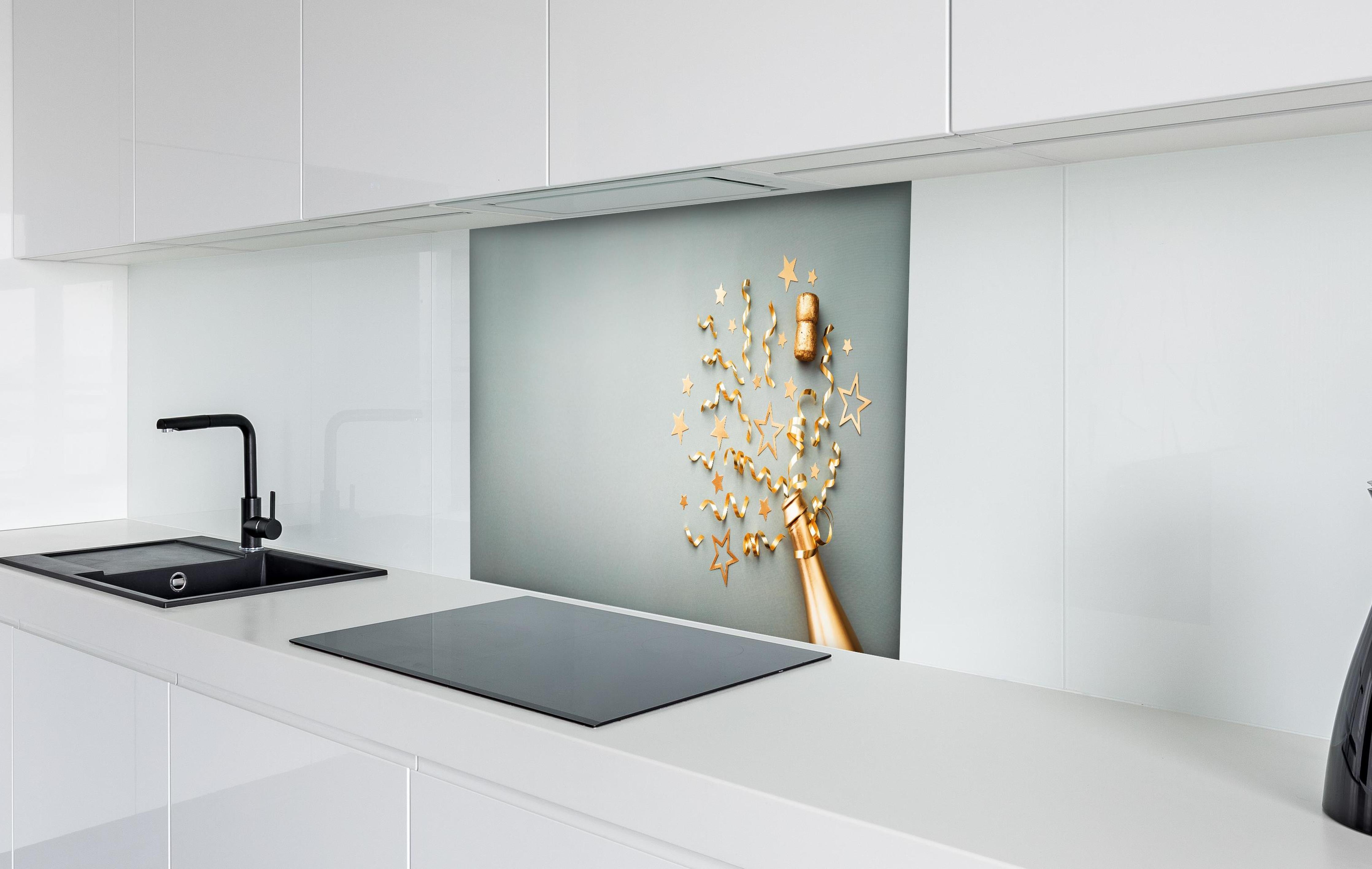 Spritzschutz - Goldene Champagnerflasche im Sylvester design hinter einem Cerankochfeld zwischen Holz-Kochutensilien