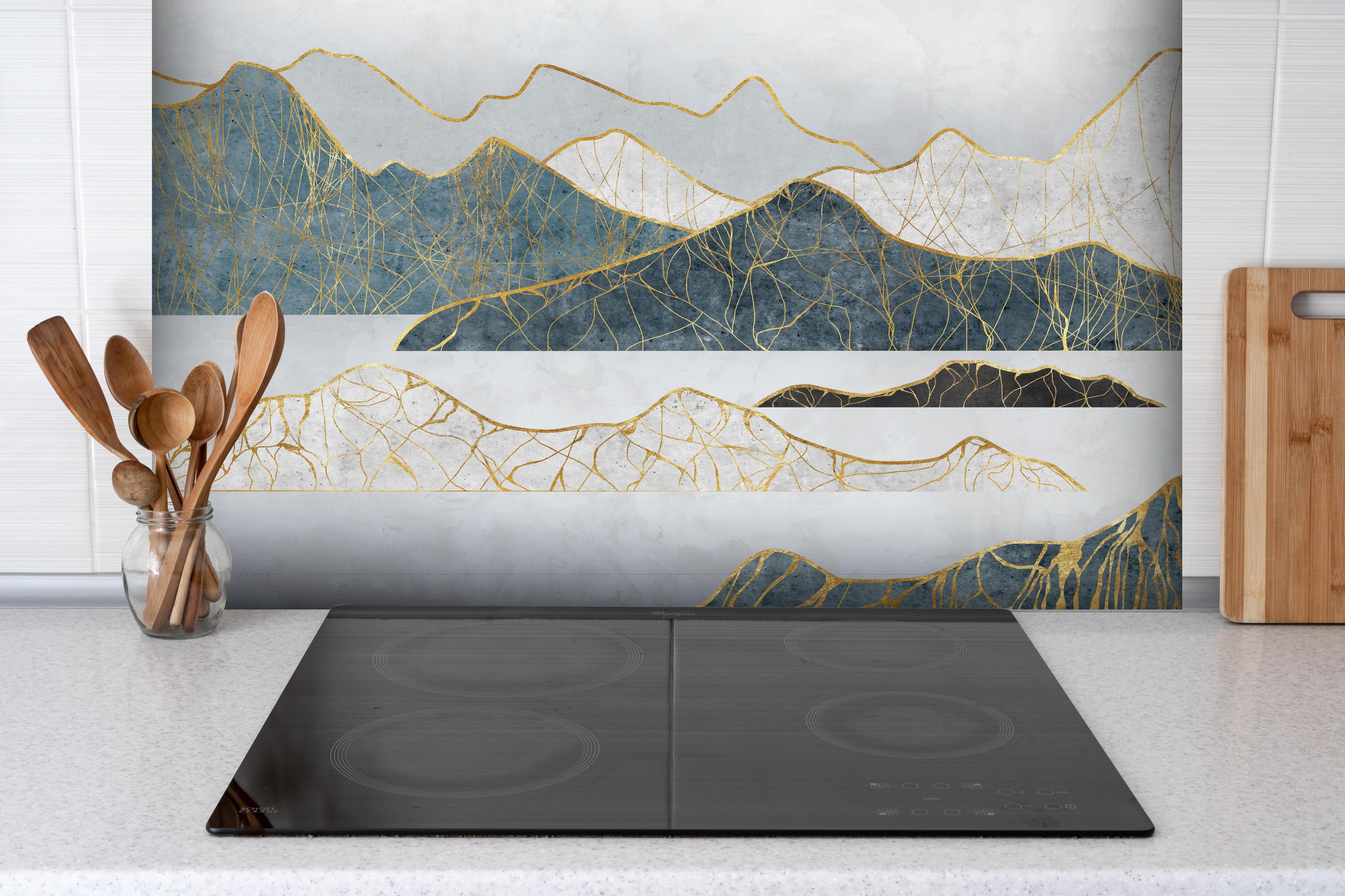 Spritzschutz - Goldene Silhouetten einer Bergregion hinter einem Cerankochfeld zwischen Holz-Kochutensilien