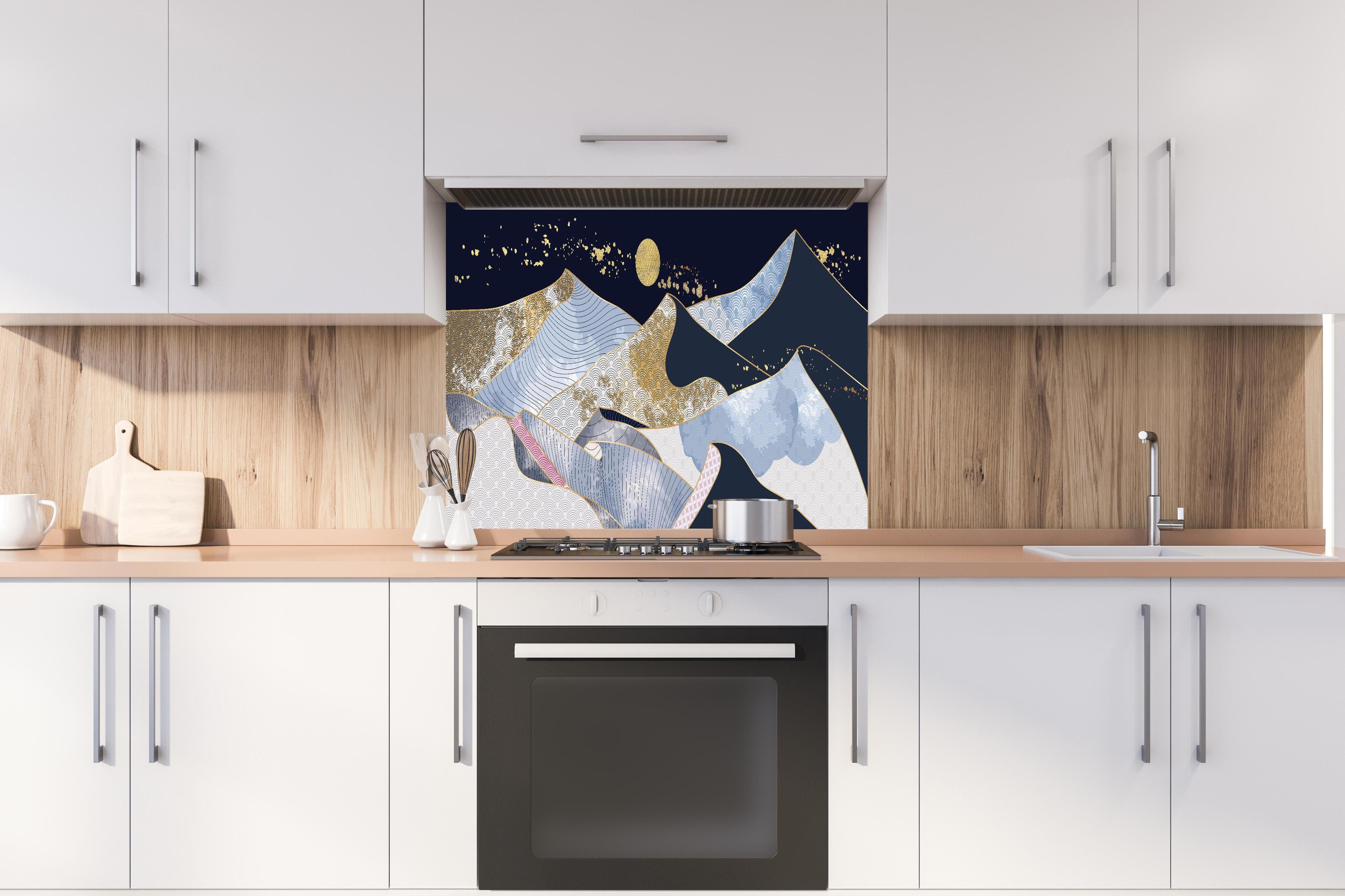 Spritzschutz - Goldener Mond über blaugrauer Abstraktlandschaft hinter einem Cerankochfeld zwischen Holz-Kochutensilien