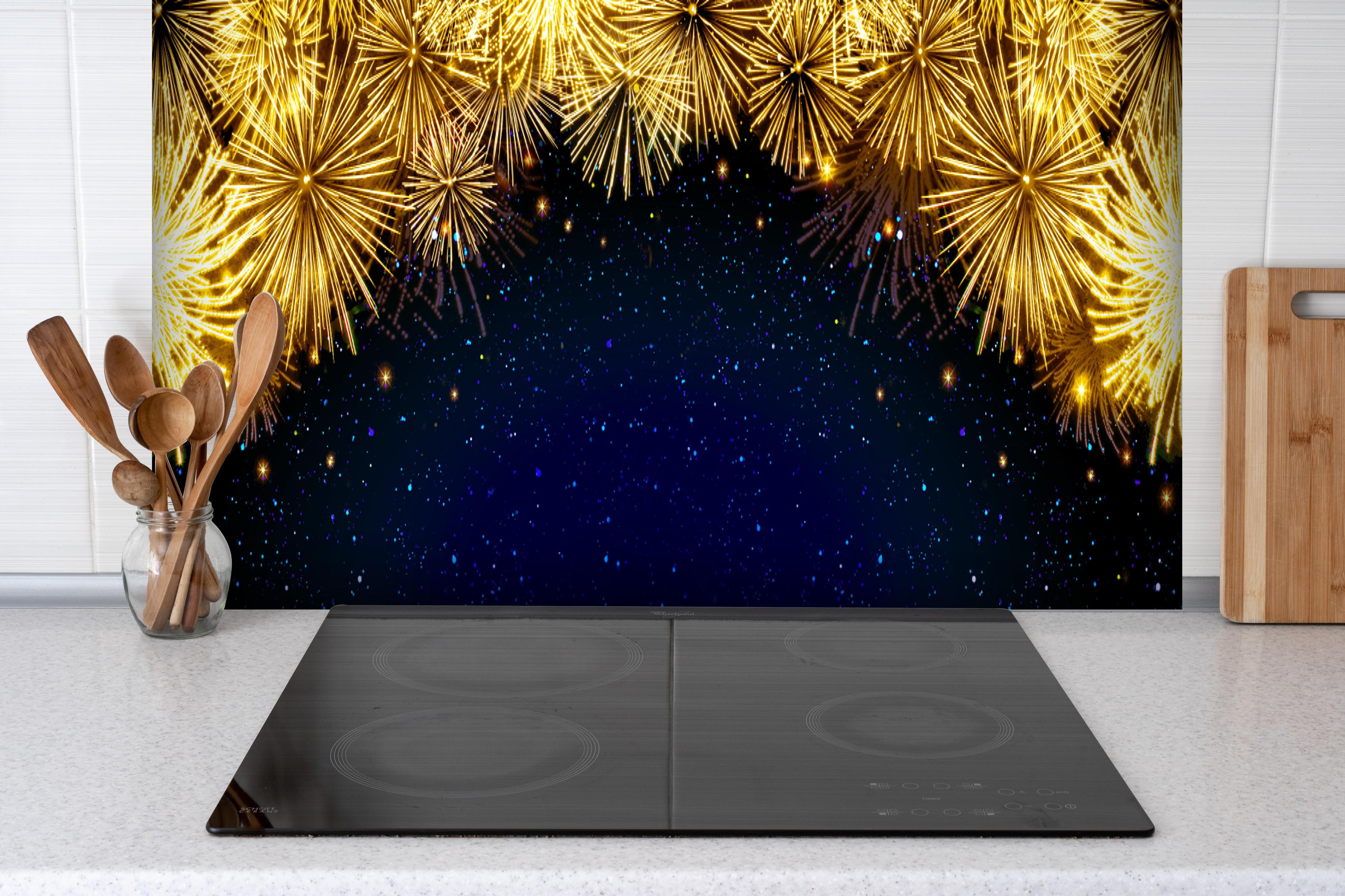 Spritzschutz - Goldenes Feuerwerk - Hintergrund hinter einem Cerankochfeld zwischen Holz-Kochutensilien