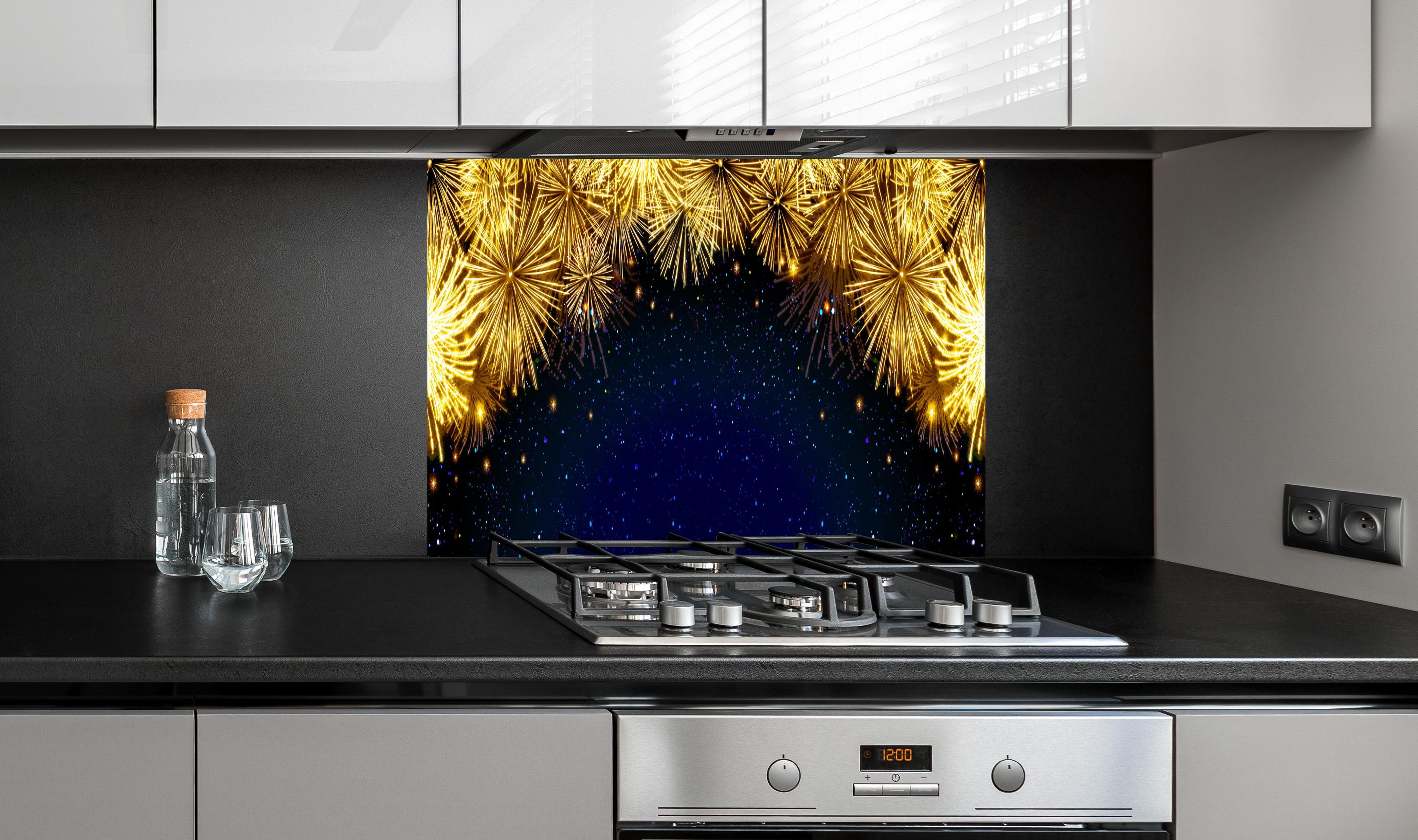 Spritzschutz - Goldenes Feuerwerk - Hintergrund hinter einem Cerankochfeld zwischen Holz-Kochutensilien