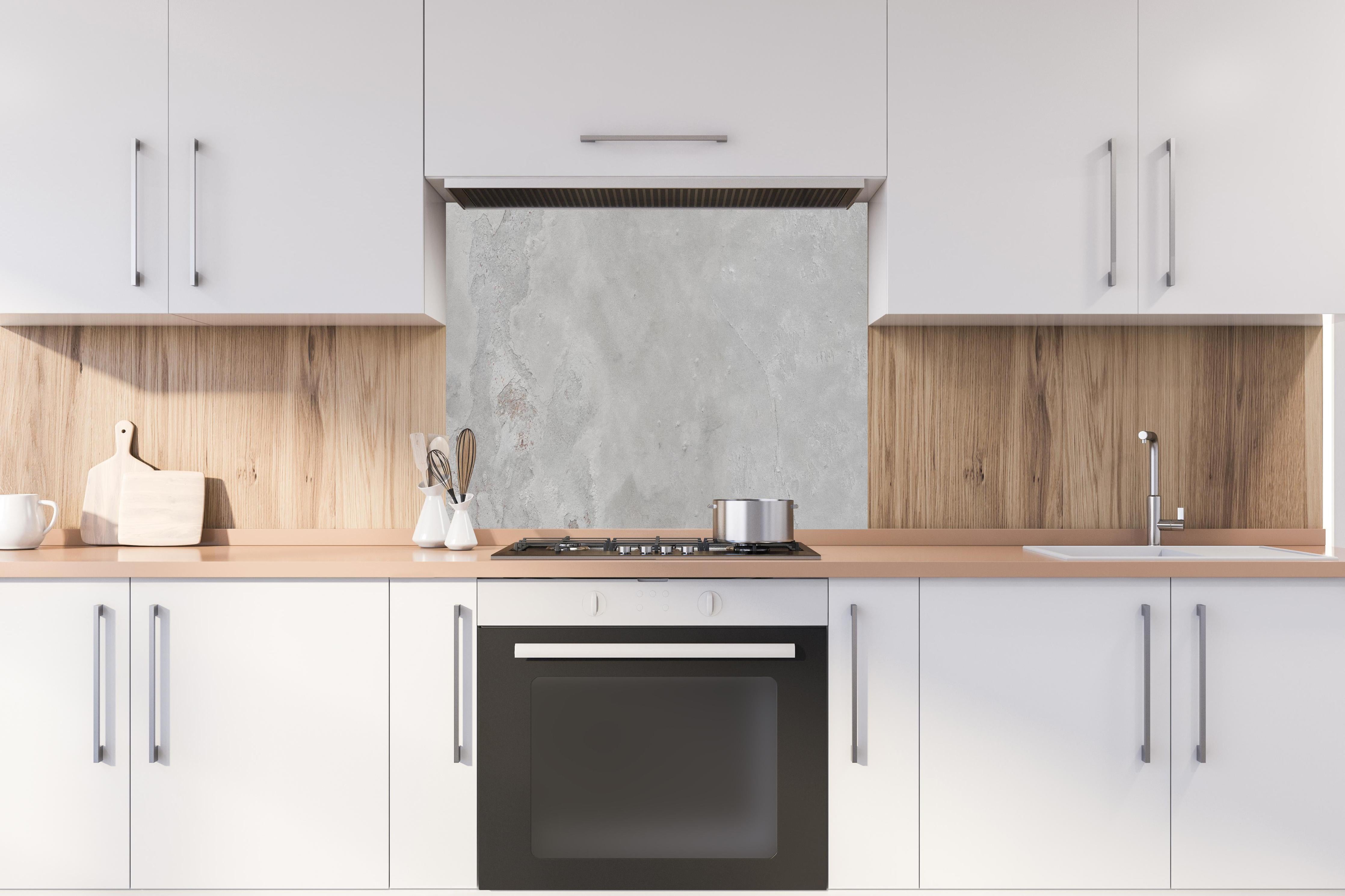 Spritzschutz - Gräuliche Naturstein Textur hinter einem Cerankochfeld zwischen Holz-Kochutensilien