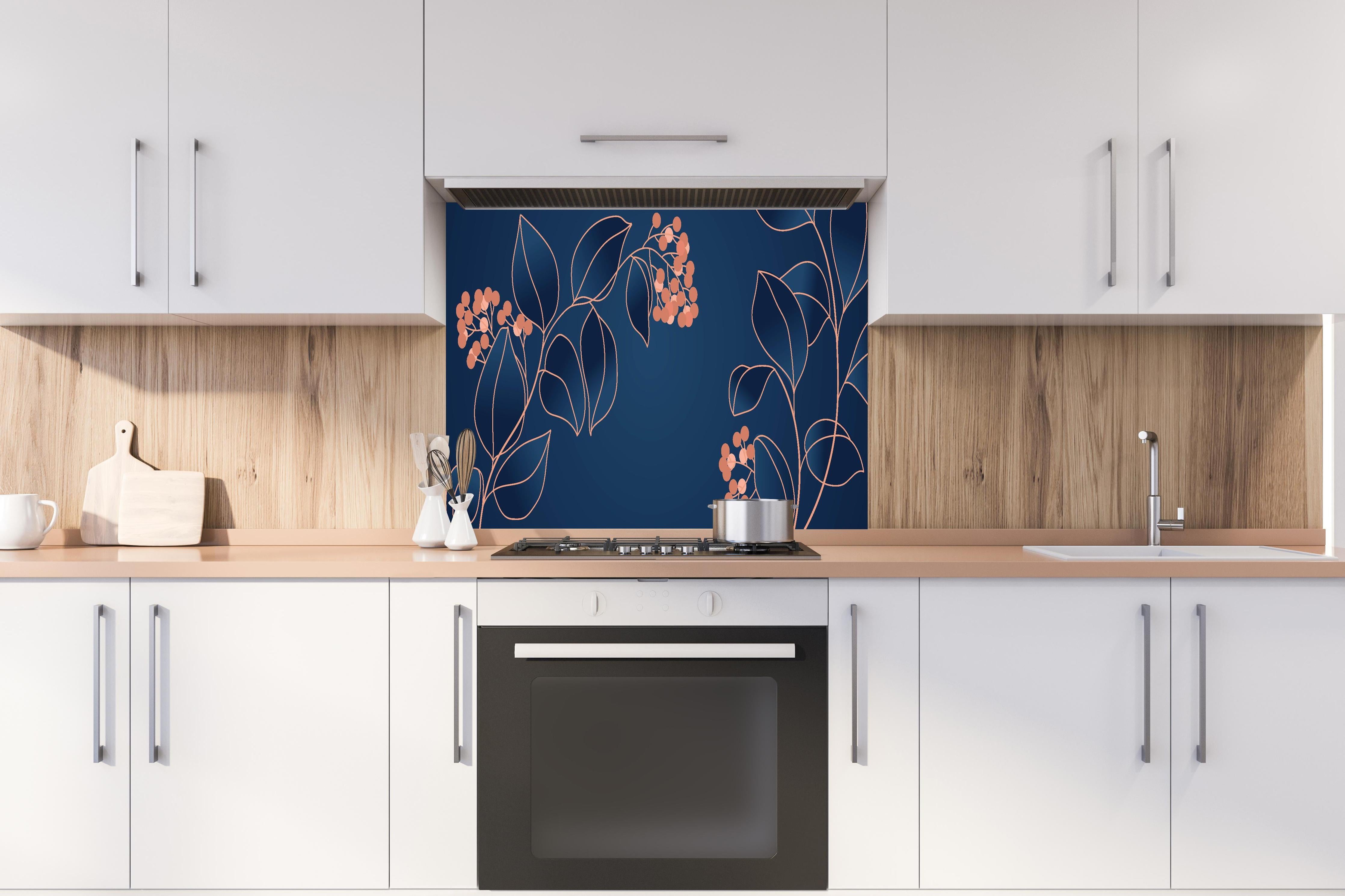 Spritzschutz - Grafische Blütenmotive in Blau und Orange hinter einem Cerankochfeld zwischen Holz-Kochutensilien