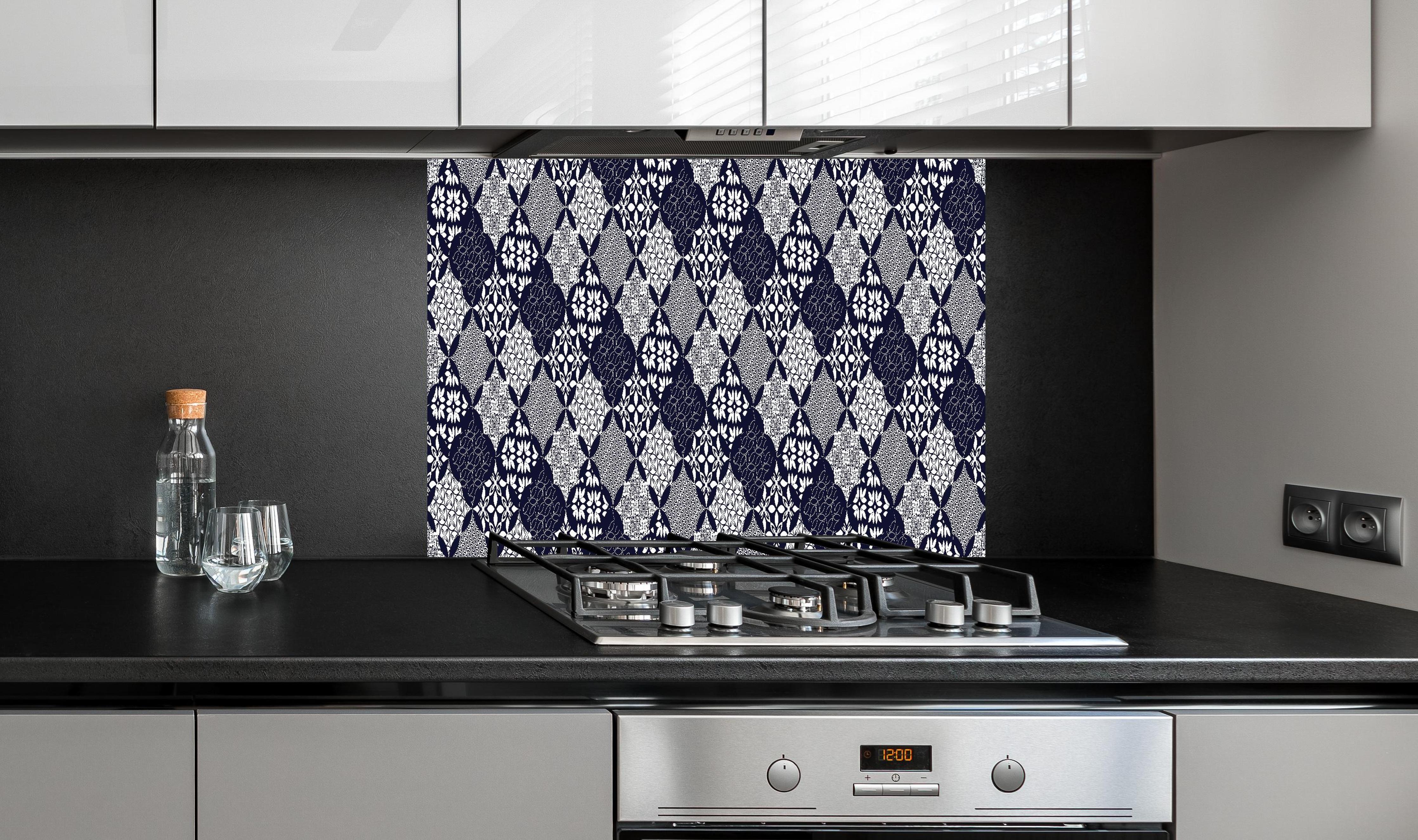 Spritzschutz - Grafisches Blau-Weiß-Grau Textildesign hinter einem Cerankochfeld zwischen Holz-Kochutensilien