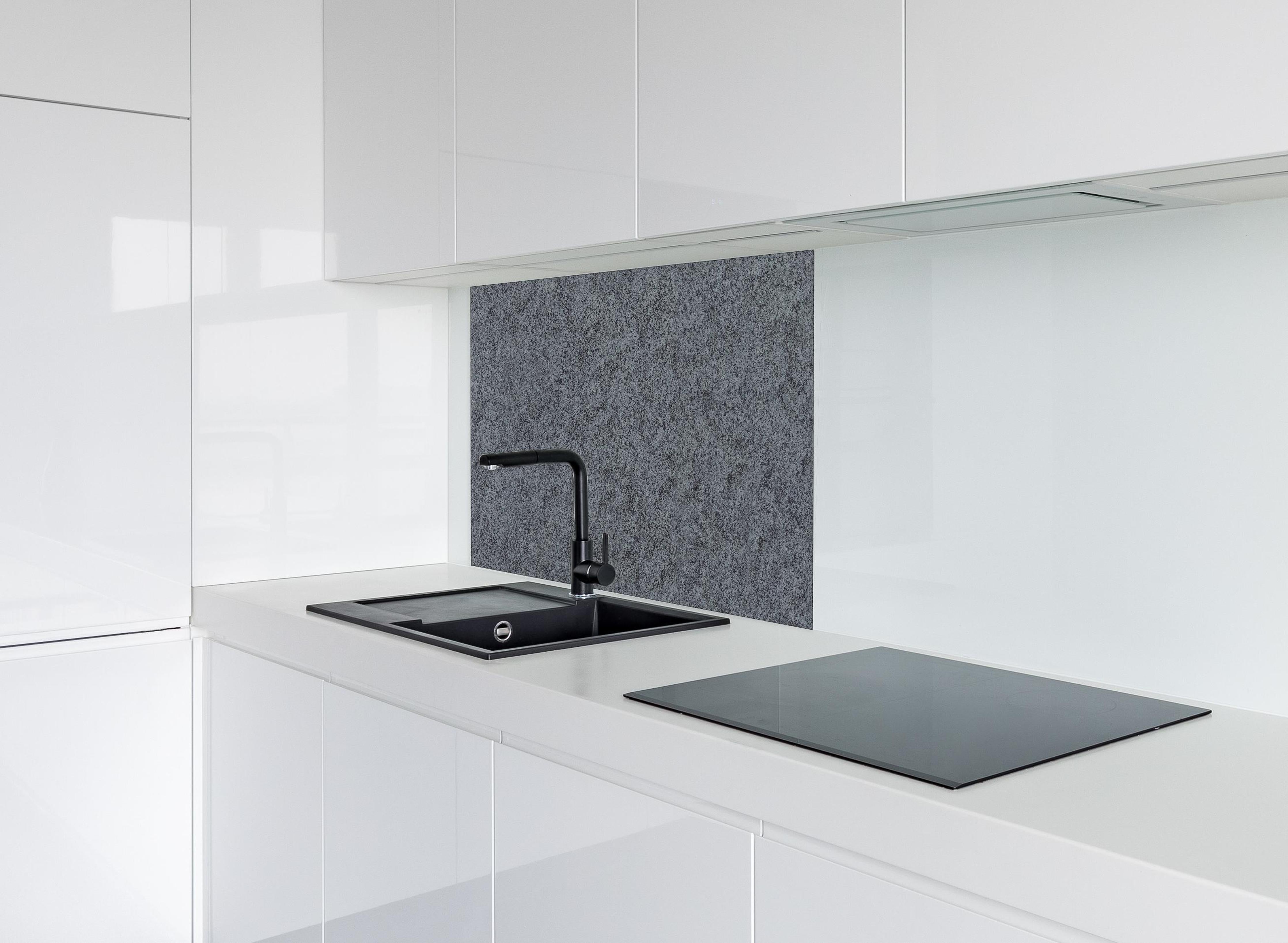 Spritzschutz - Granit Marmor Textur hinter einem Cerankochfeld zwischen Holz-Kochutensilien