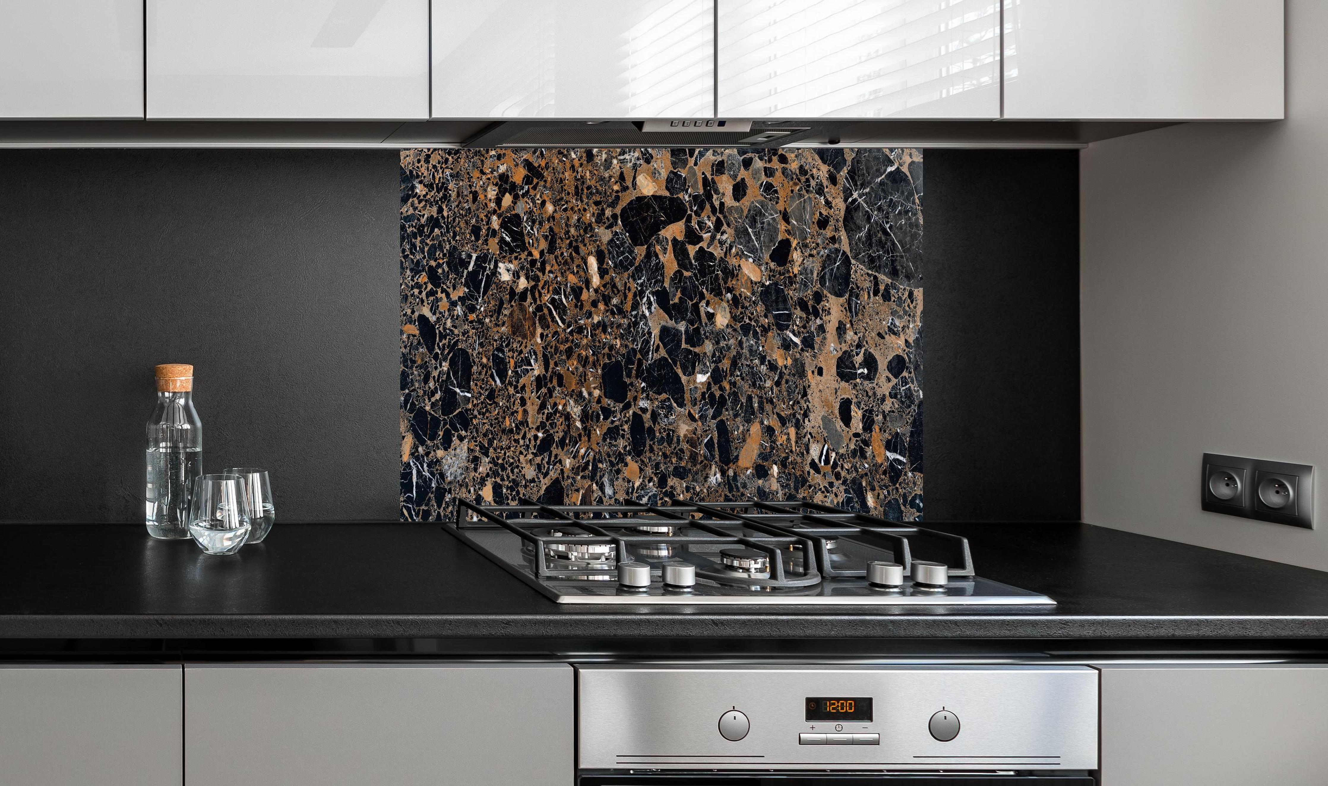 Spritzschutz - Granit luxus Textur hinter einem Cerankochfeld zwischen Holz-Kochutensilien