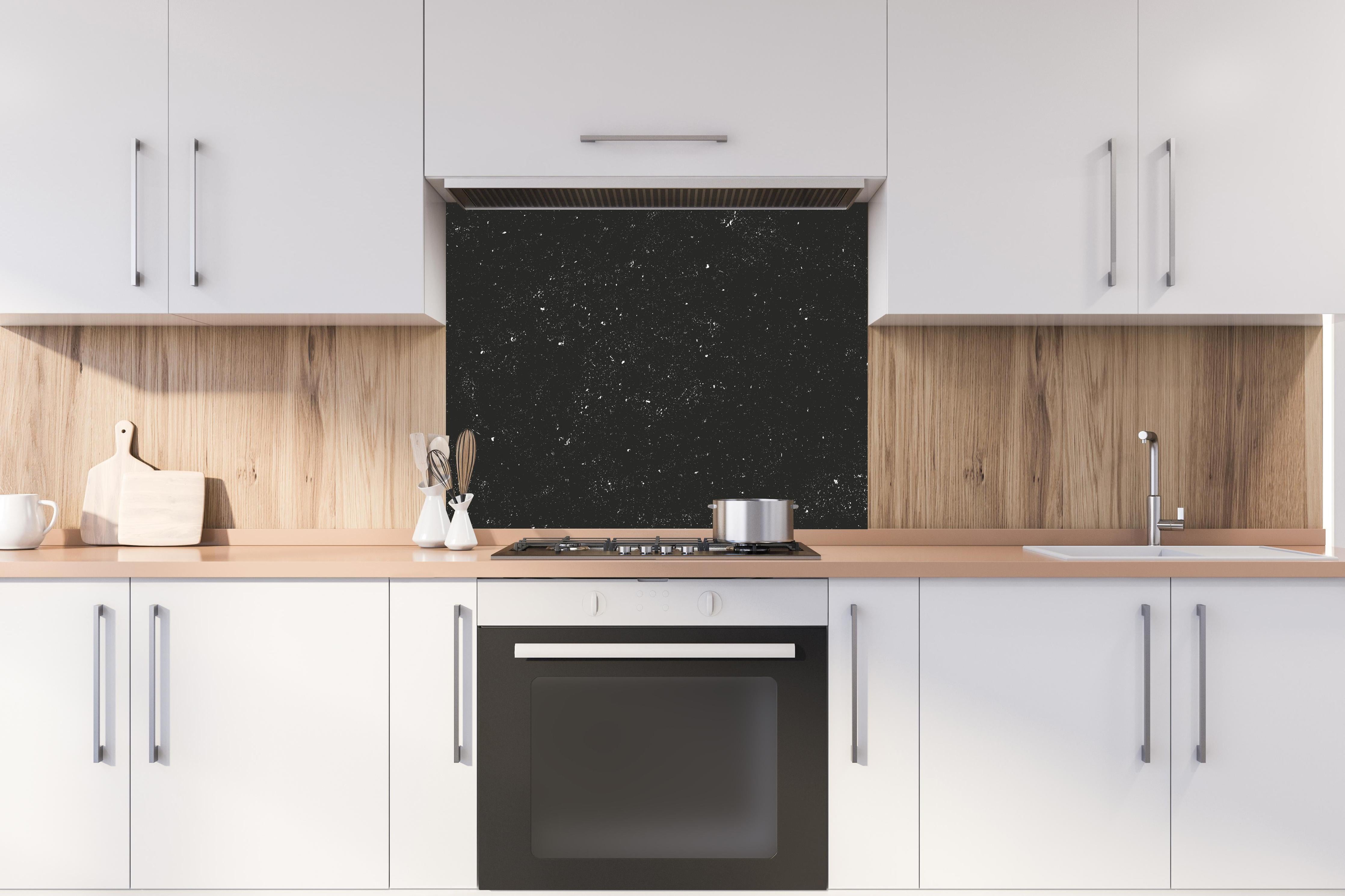 Spritzschutz - Grau-Schwarze Textur mit Betonrisseffekt hinter einem Cerankochfeld zwischen Holz-Kochutensilien