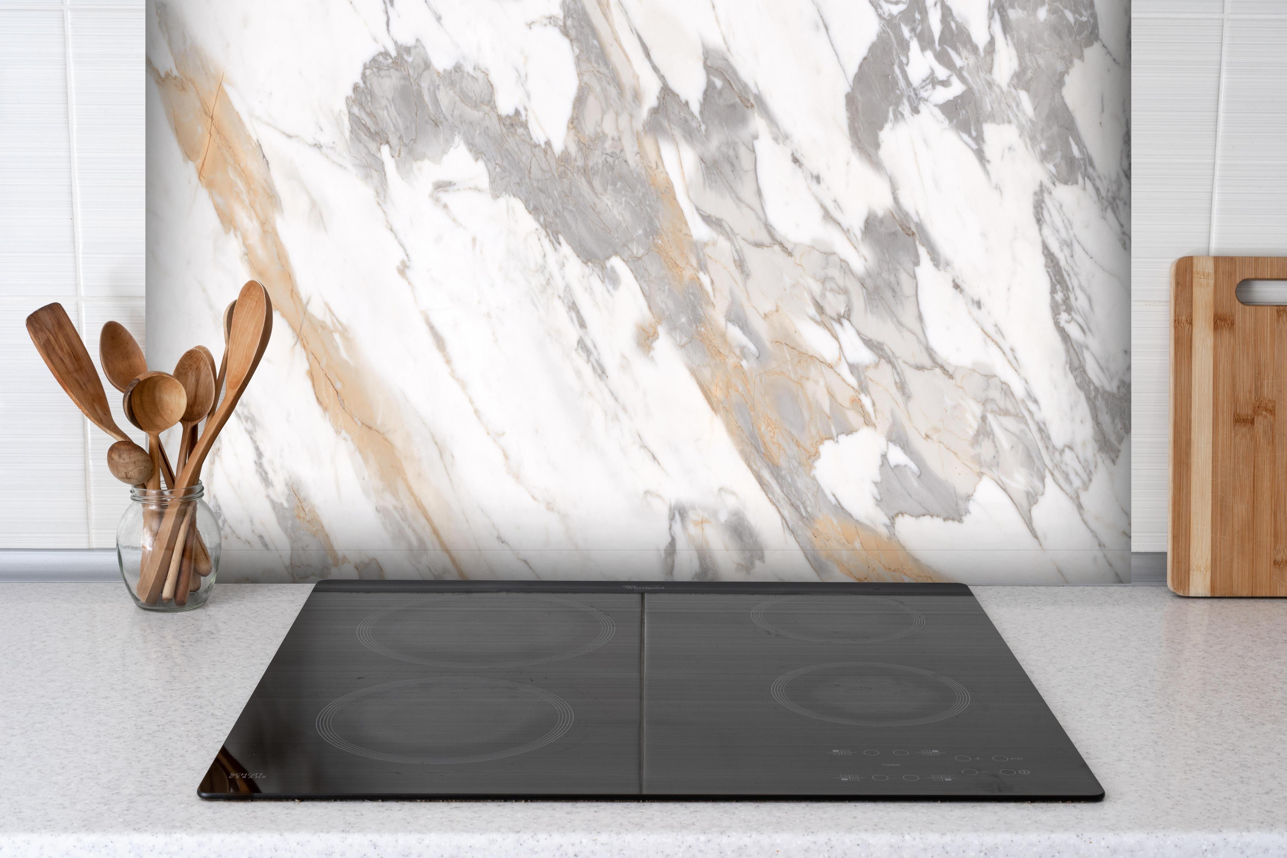 Spritzschutz - Grau-beiger abstrakter Marmor hinter einem Cerankochfeld zwischen Holz-Kochutensilien