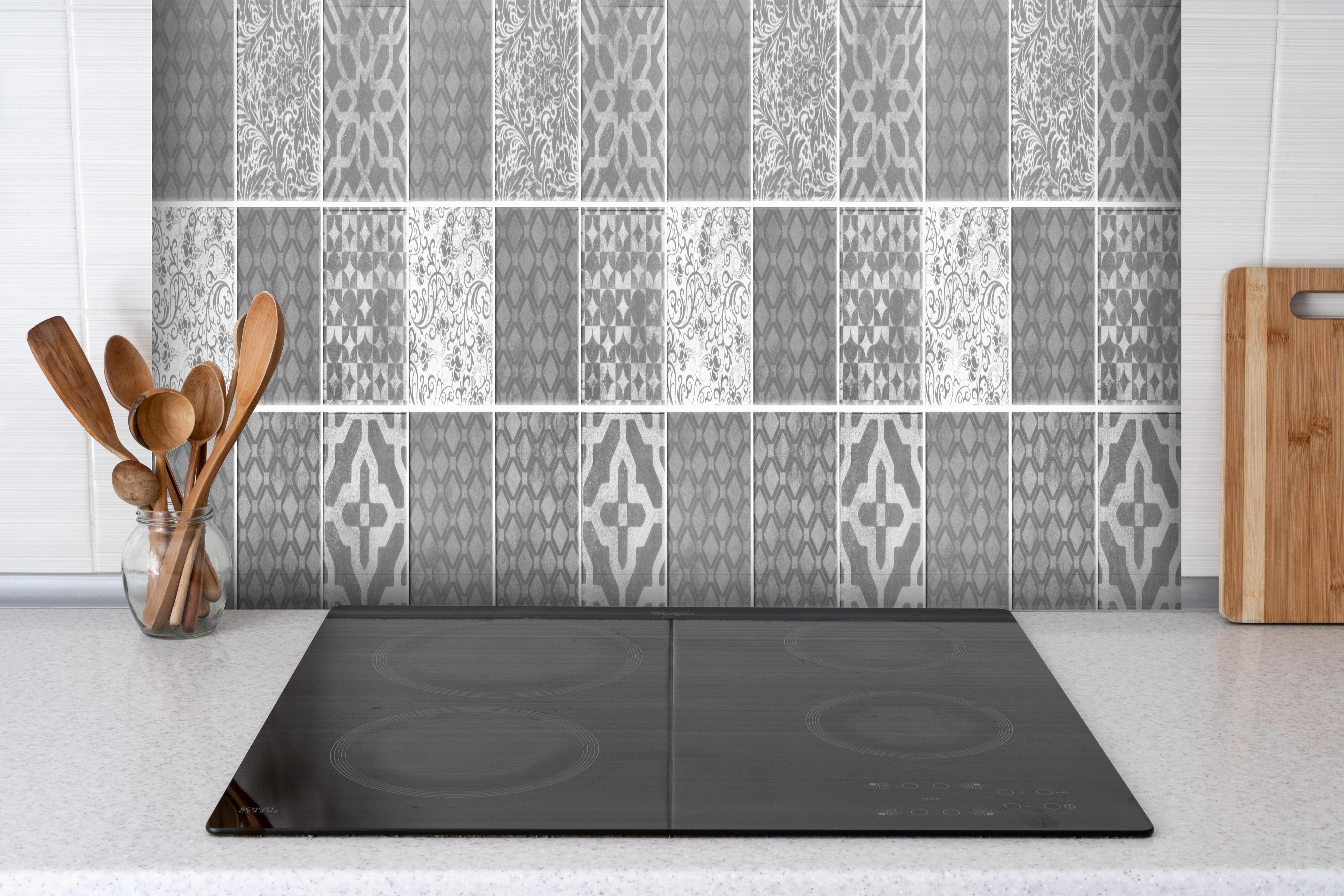 Spritzschutz - Grau weiße Vintage Mosaik Textur hinter einem Cerankochfeld zwischen Holz-Kochutensilien