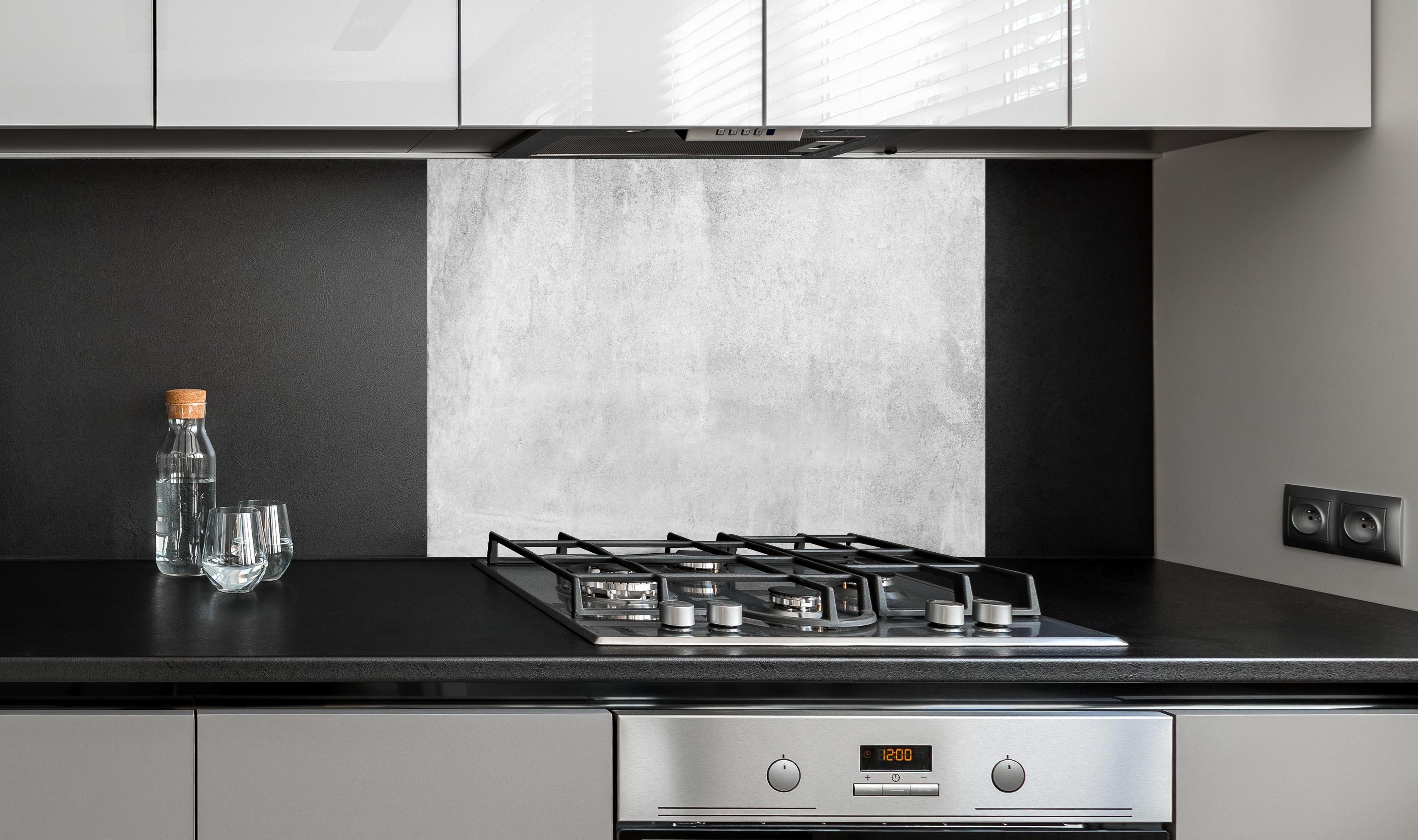 Spritzschutz - Graue Grunge Betonwand hinter einem Cerankochfeld zwischen Holz-Kochutensilien