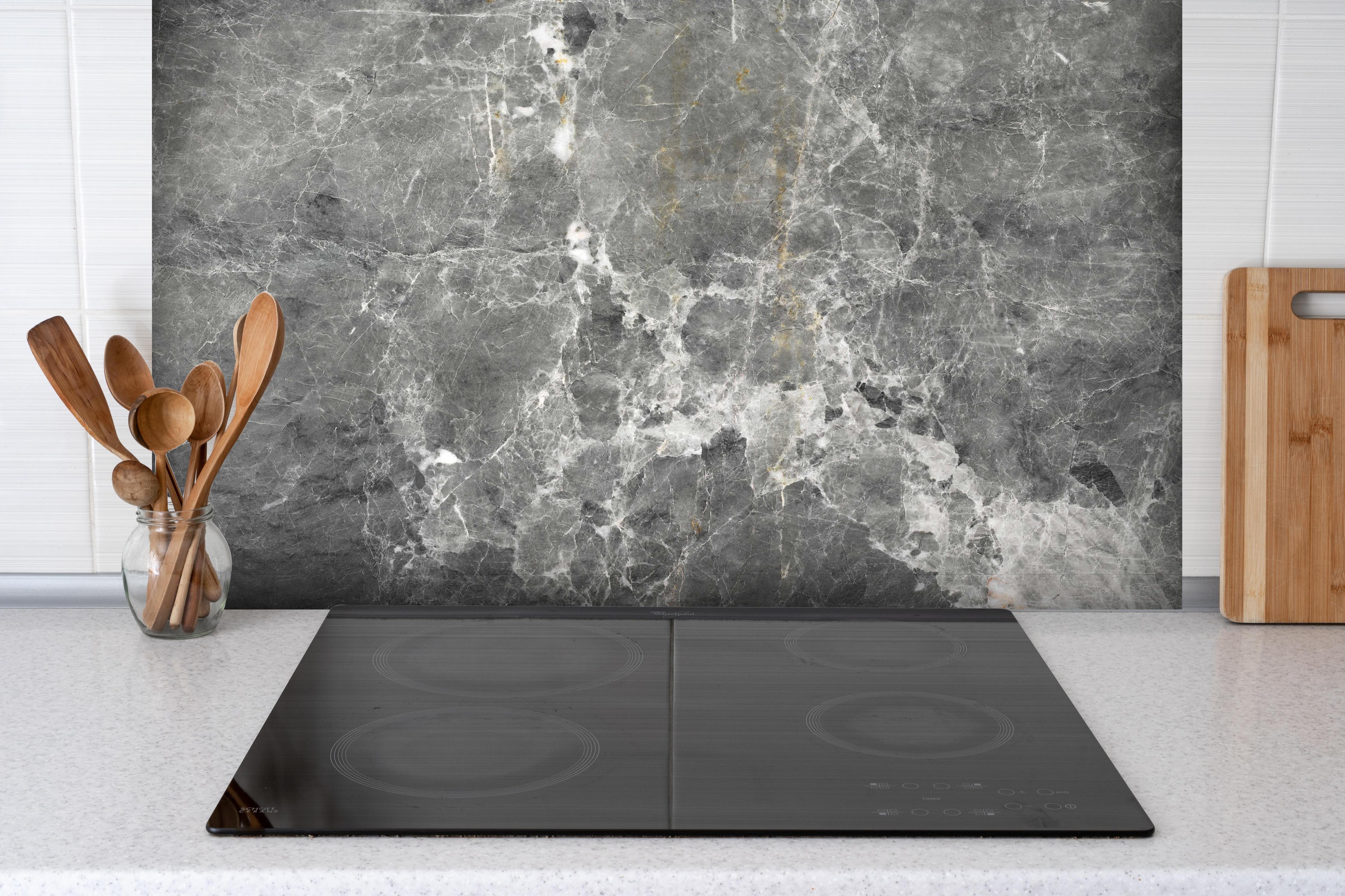 Spritzschutz - Graue Marmorstein Textur hinter einem Cerankochfeld zwischen Holz-Kochutensilien