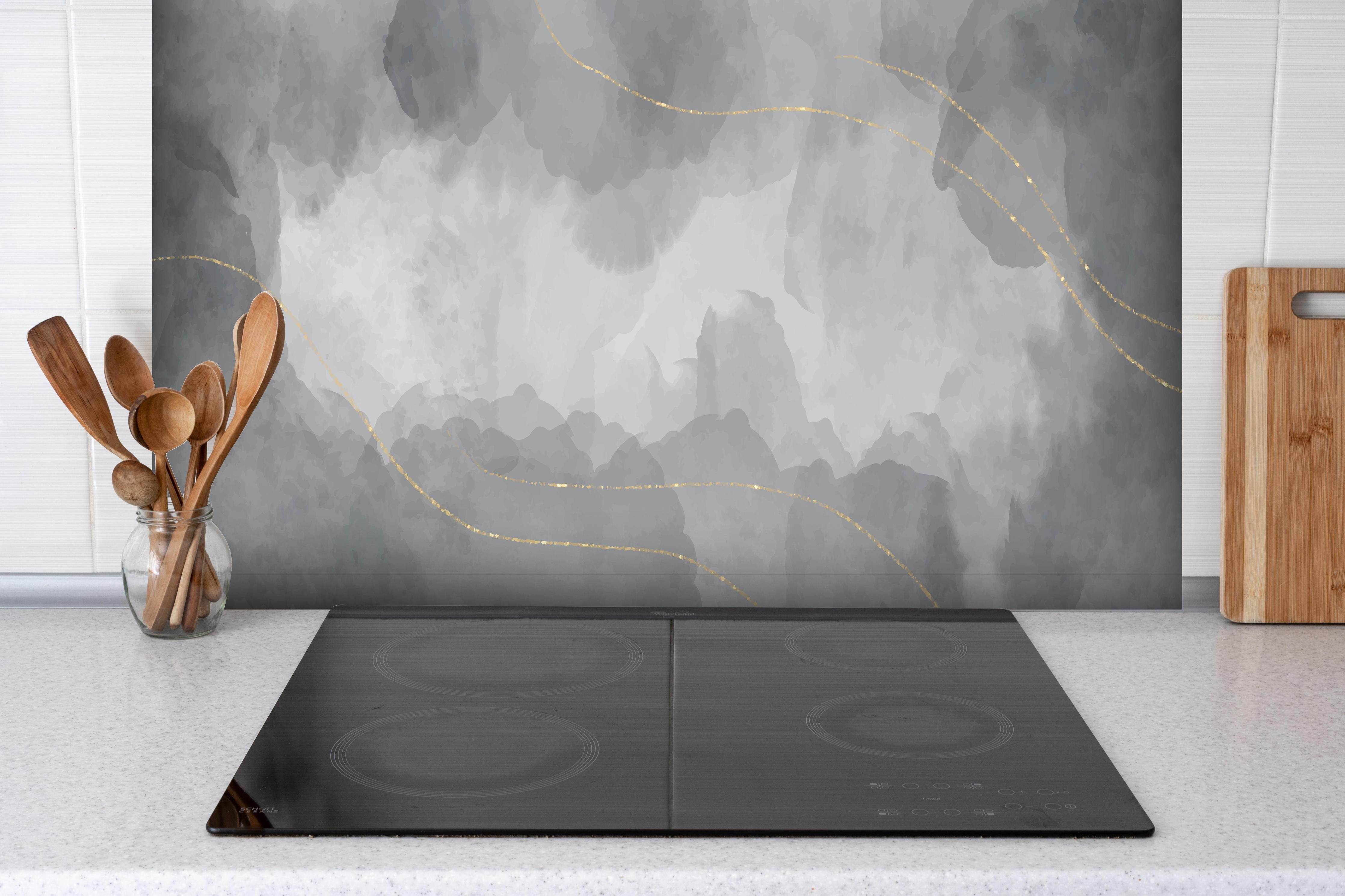 Spritzschutz - Graue Marmorstruktur mit goldenen Adern hinter einem Cerankochfeld zwischen Holz-Kochutensilien