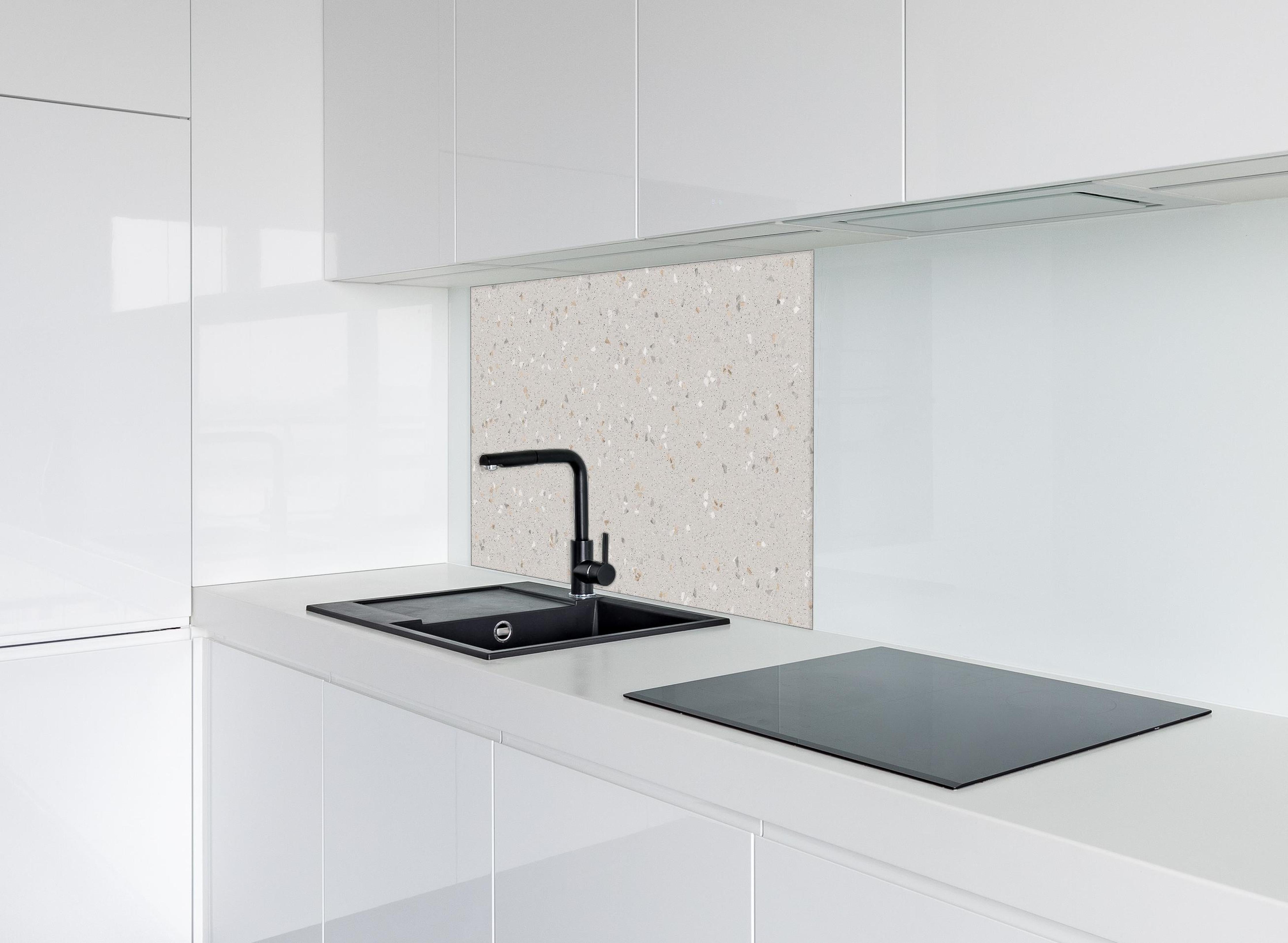 Spritzschutz - Graue Mosaiksteine hinter einem Cerankochfeld zwischen Holz-Kochutensilien