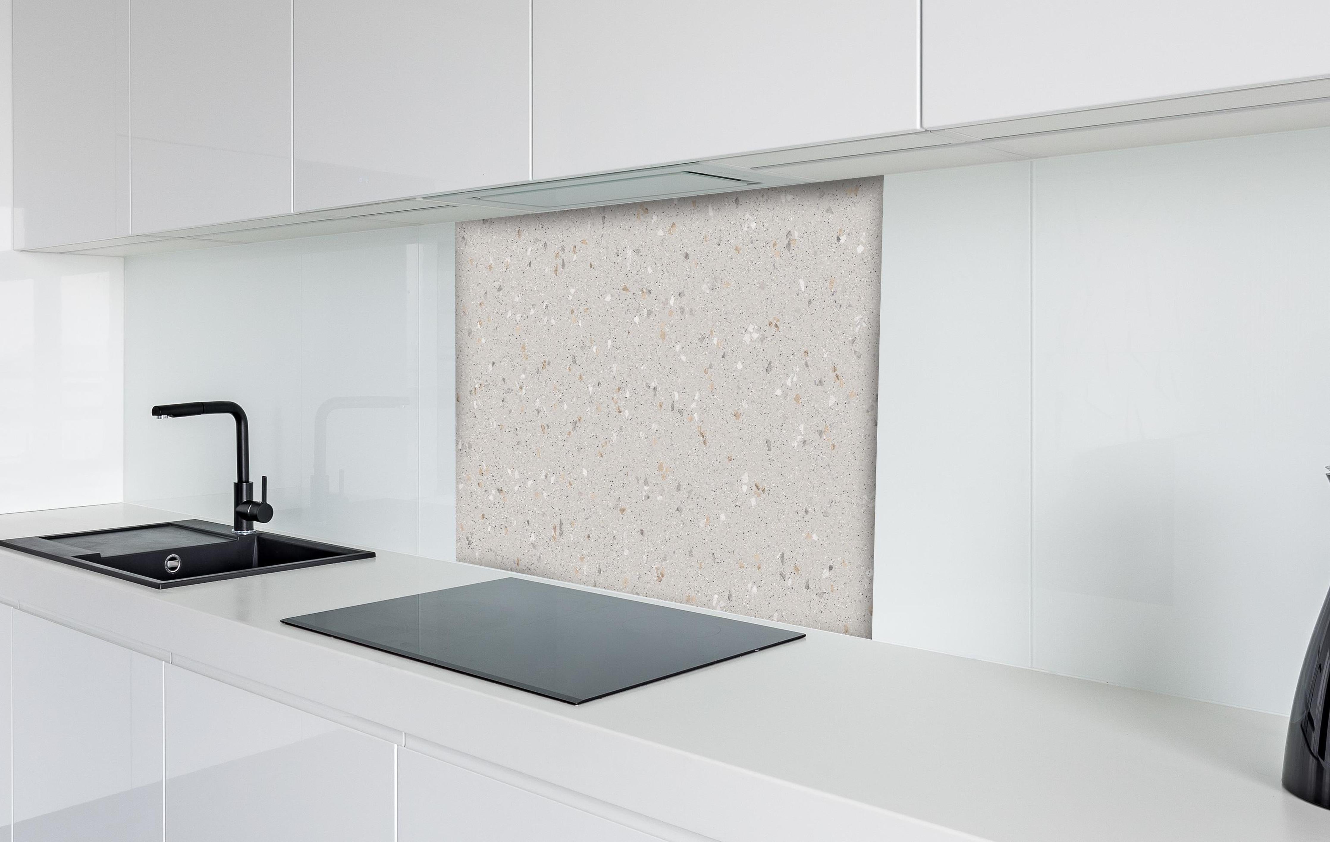 Spritzschutz - Graue Mosaiksteine hinter einem Cerankochfeld zwischen Holz-Kochutensilien