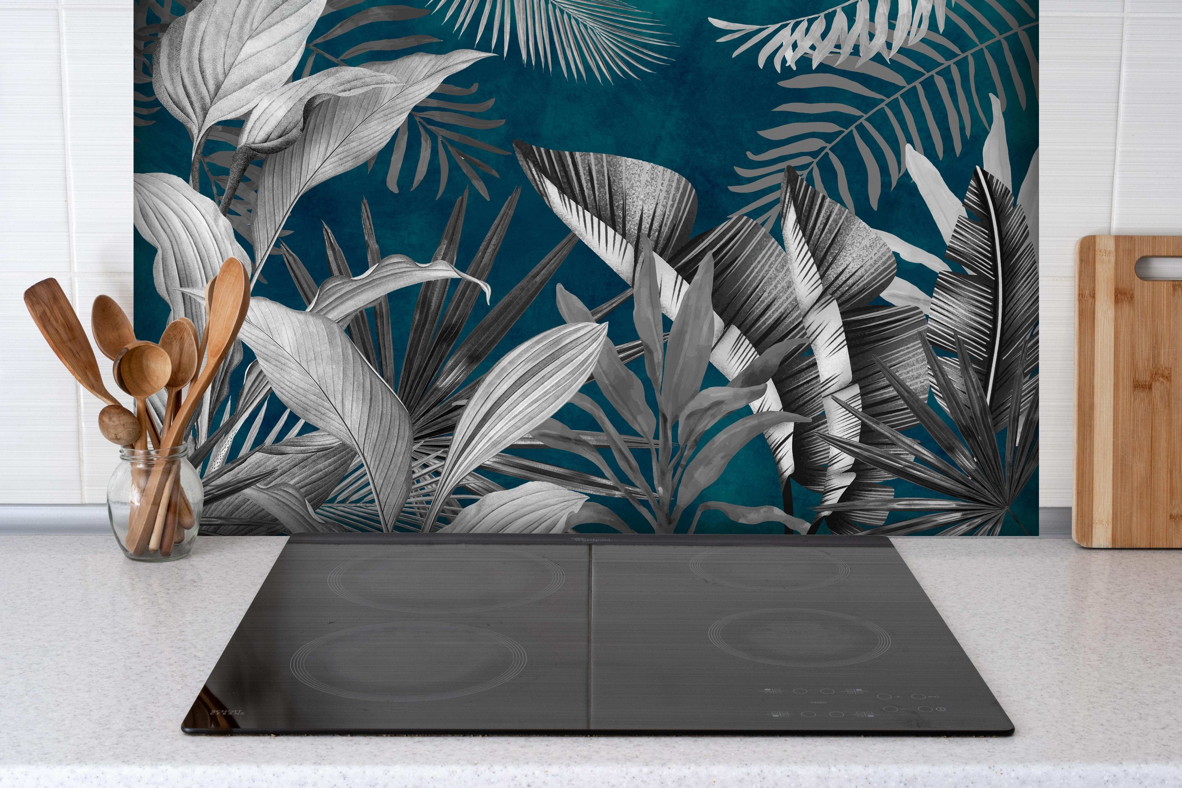 Spritzschutz - Graue Pflanzen auf blauem Hintergrund hinter einem Cerankochfeld zwischen Holz-Kochutensilien