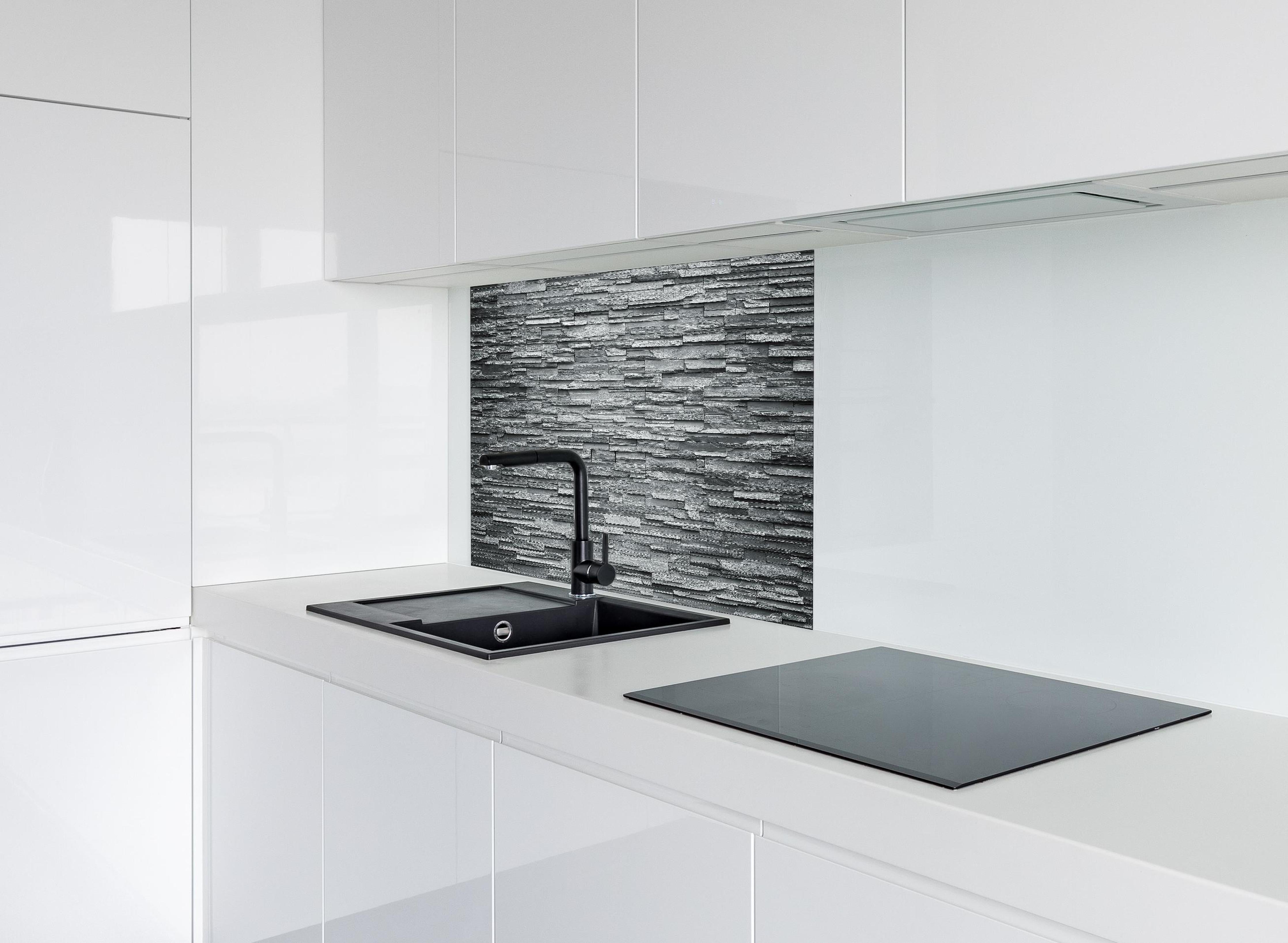 Spritzschutz - Graue Steinziegel hinter einem Cerankochfeld zwischen Holz-Kochutensilien