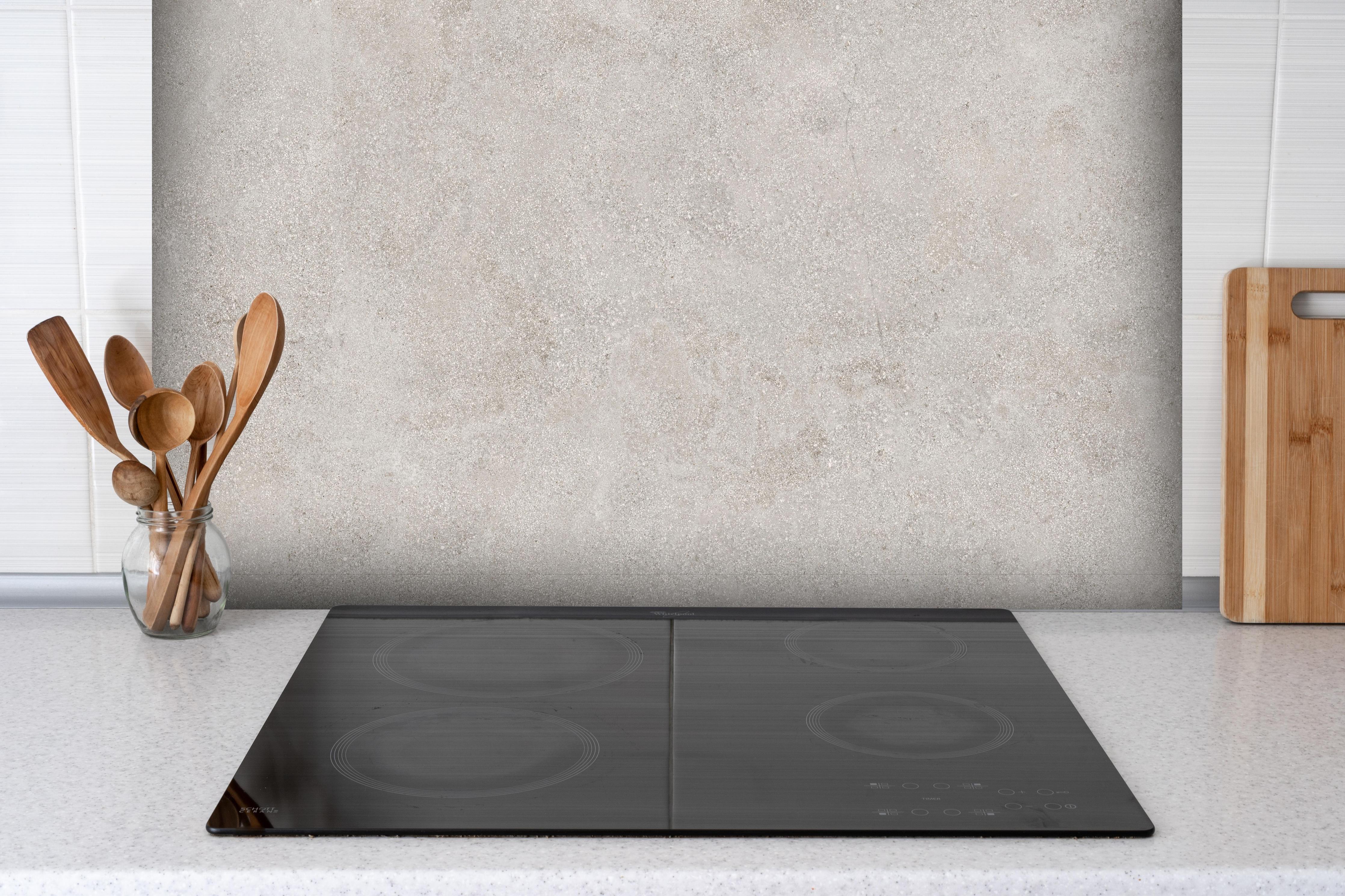 Spritzschutz - Graue Zement Struktur hinter einem Cerankochfeld zwischen Holz-Kochutensilien