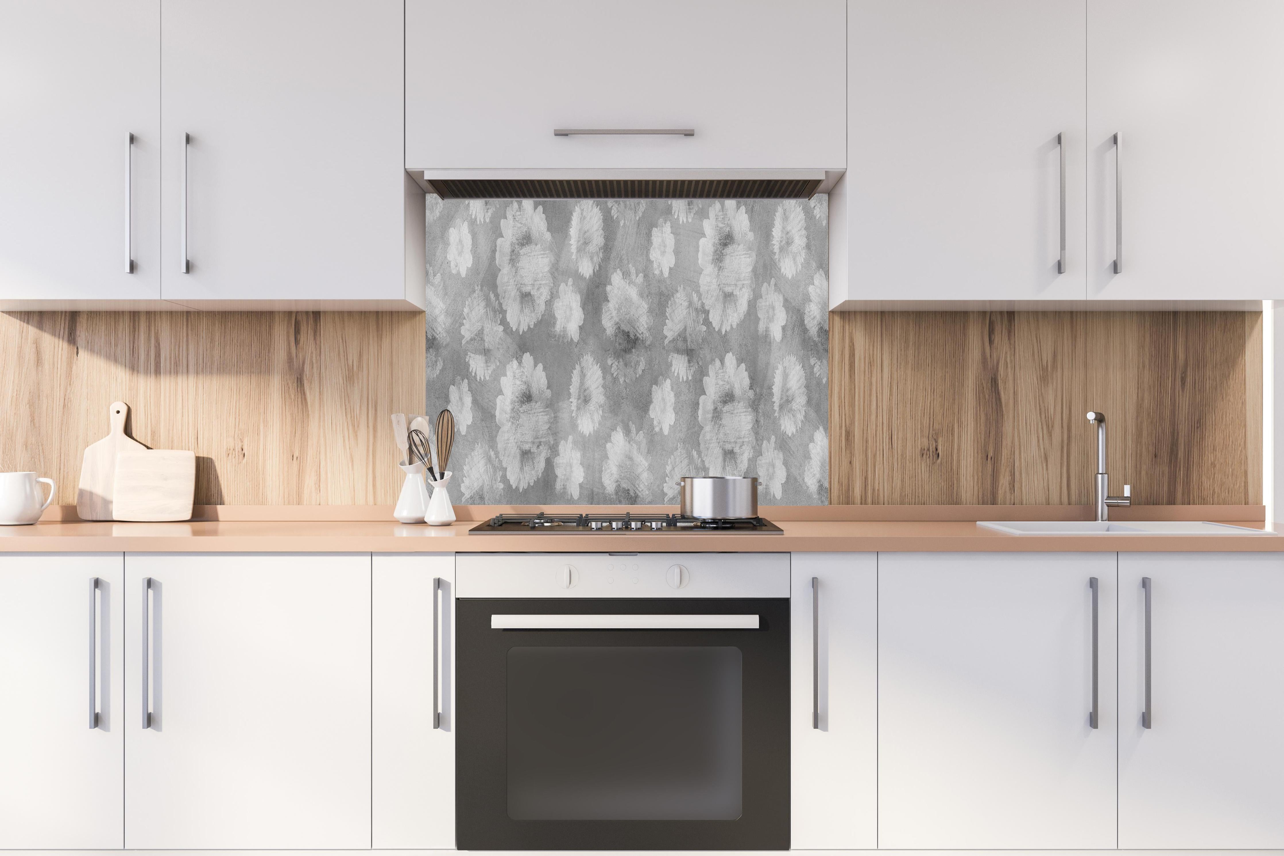 Spritzschutz - Graue Zement Wand mit weißem Blumenmuster hinter einem Cerankochfeld zwischen Holz-Kochutensilien
