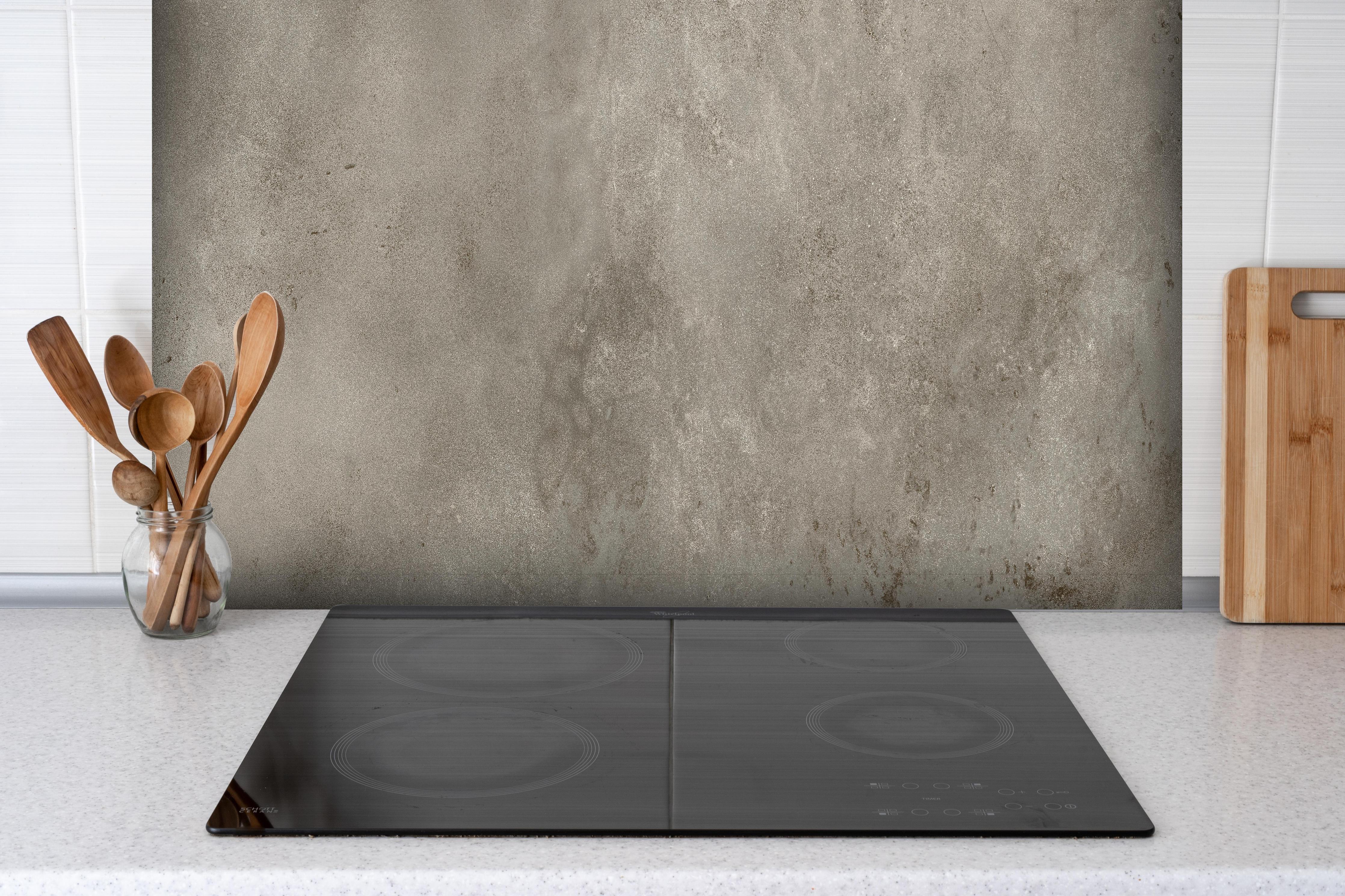 Spritzschutz - Graue alte Kalksteinwand hinter einem Cerankochfeld zwischen Holz-Kochutensilien