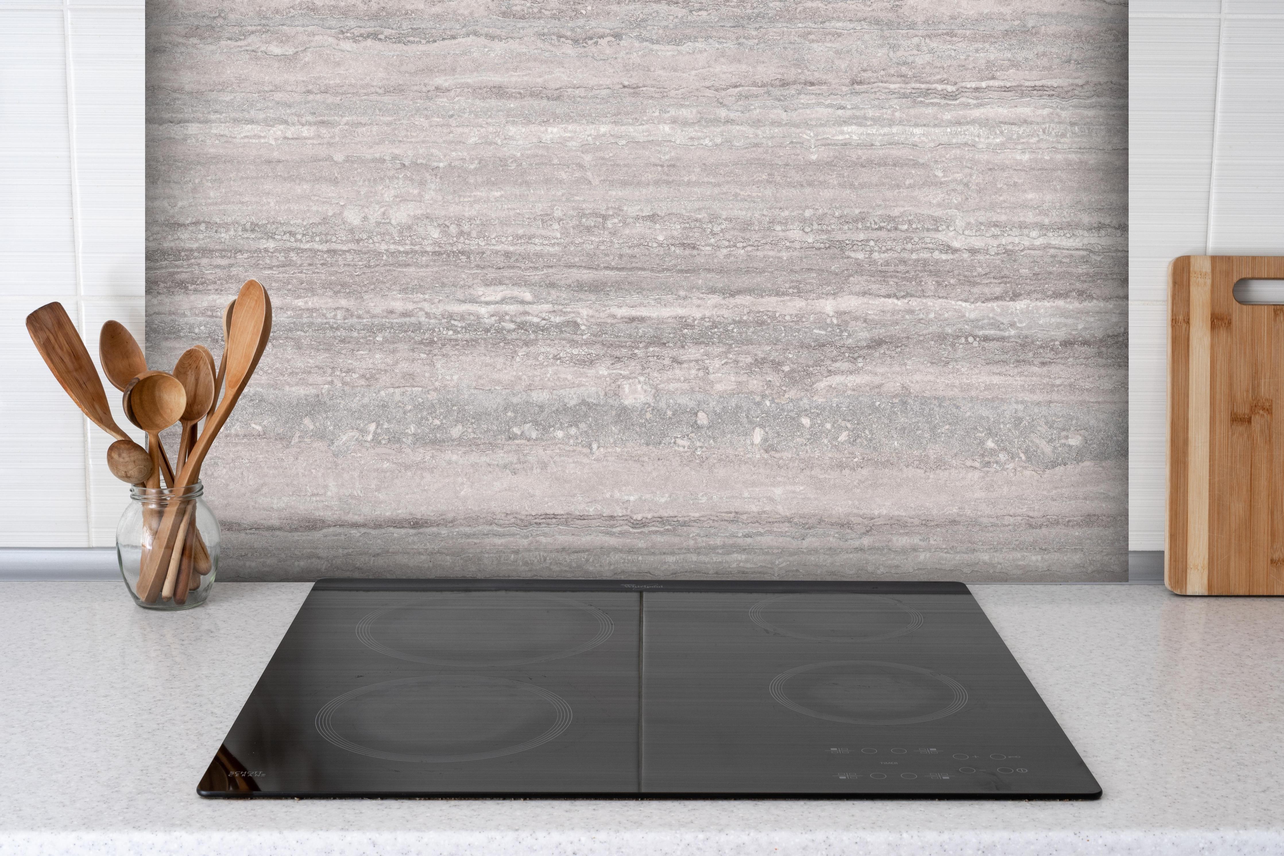 Spritzschutz - Grauer Travertin Stein hinter einem Cerankochfeld zwischen Holz-Kochutensilien