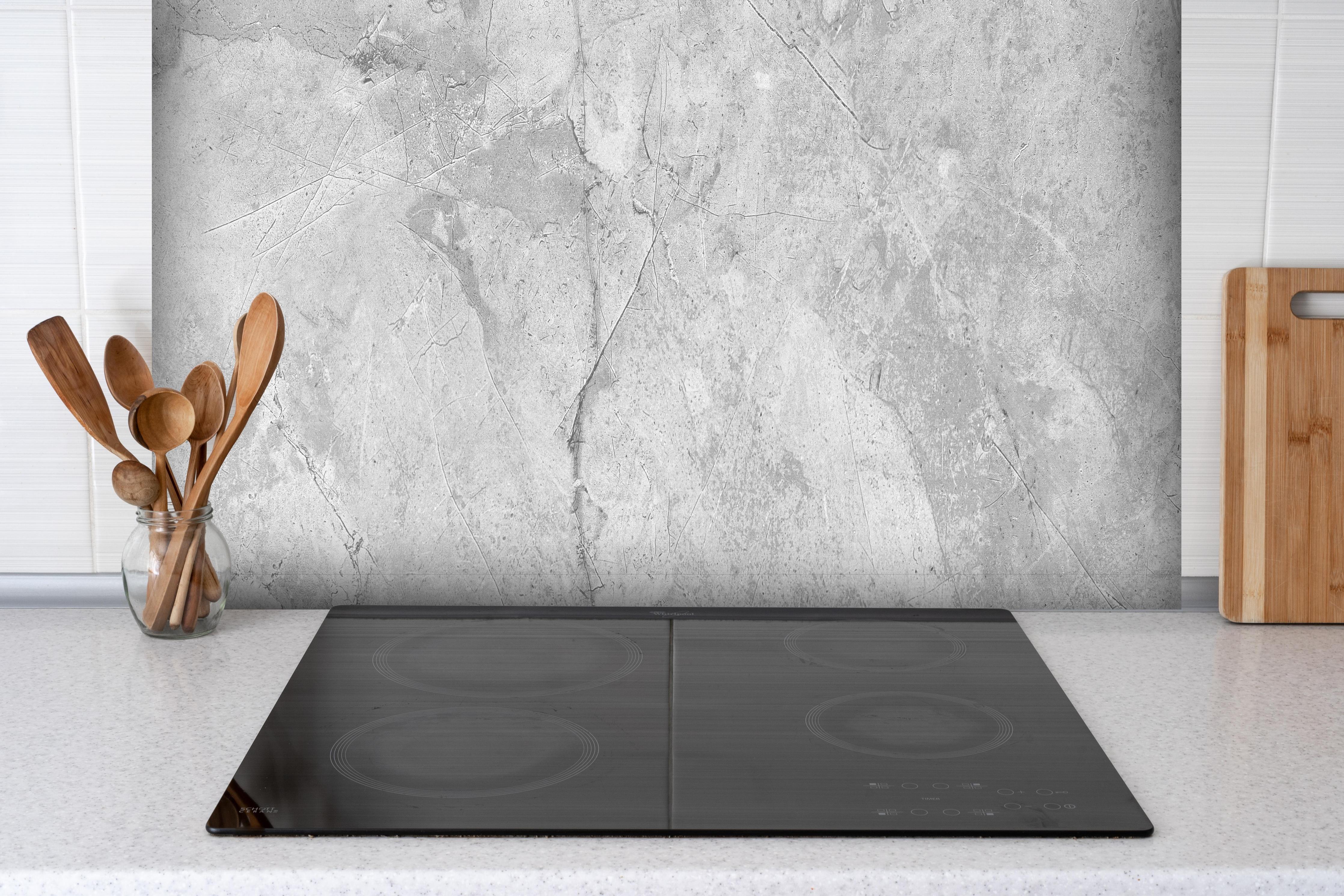 Spritzschutz - Graues Betonmuster hinter einem Cerankochfeld zwischen Holz-Kochutensilien