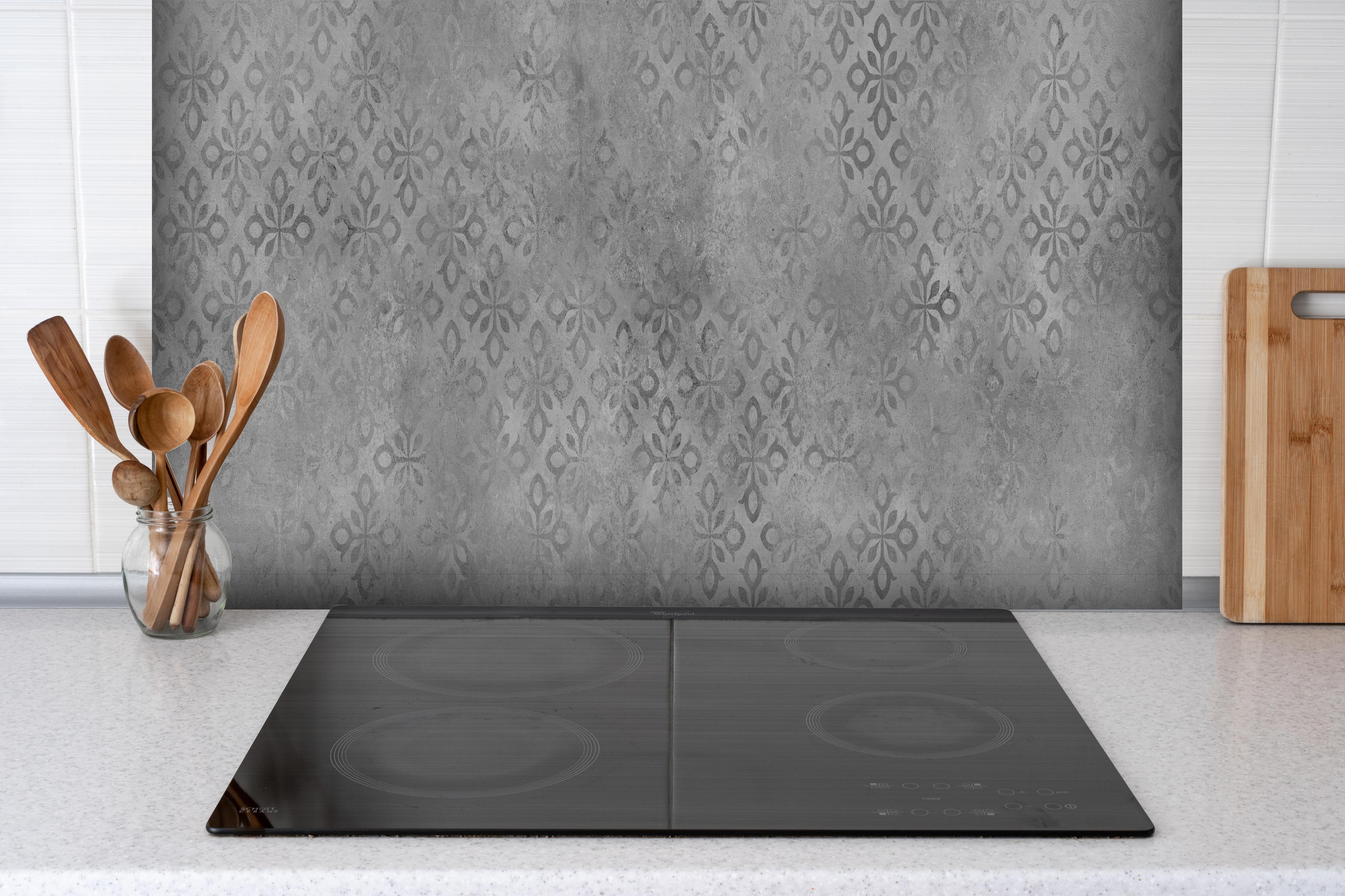 Spritzschutz - Graues Ornament Muster hinter einem Cerankochfeld zwischen Holz-Kochutensilien