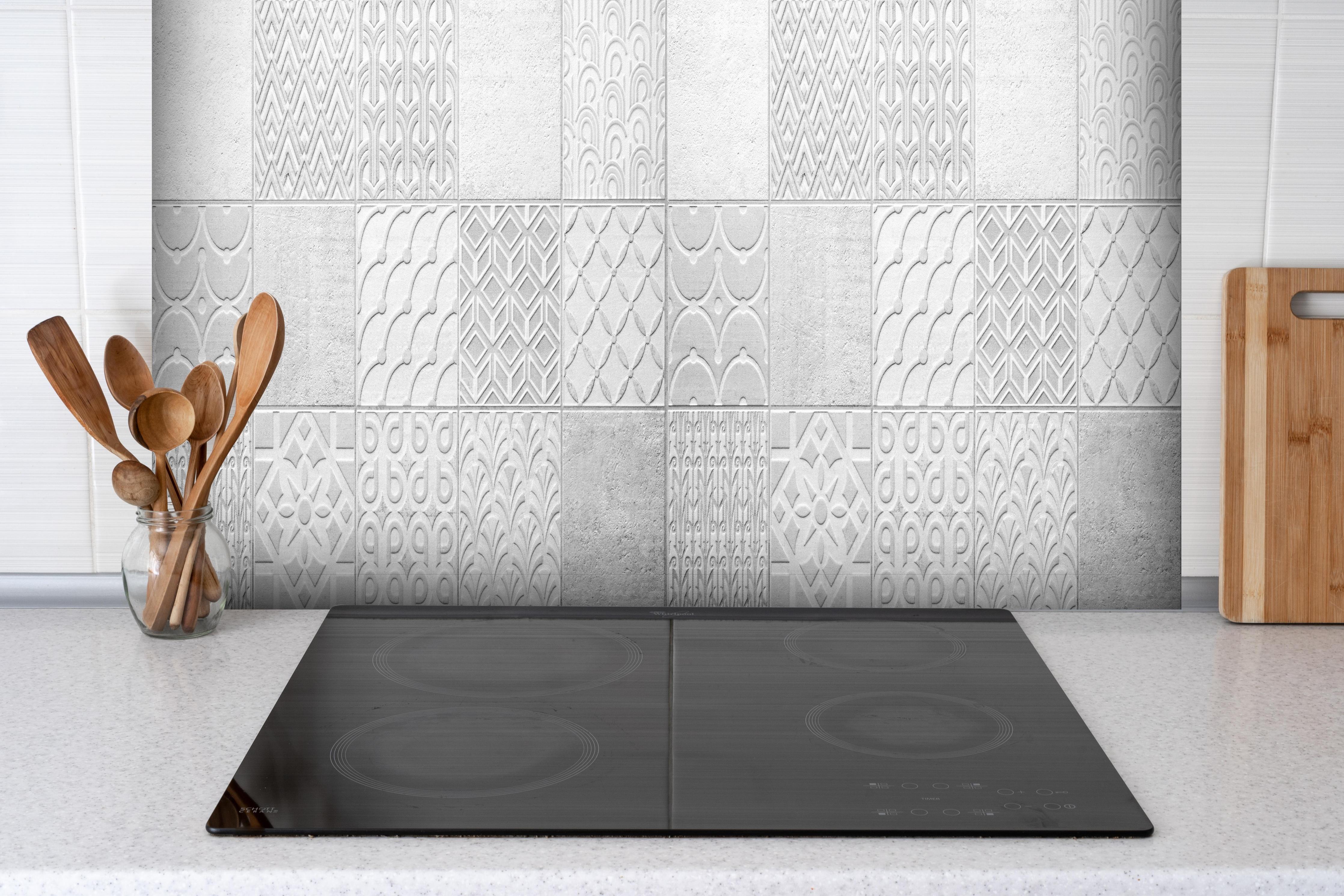 Spritzschutz - Graues weißes Vintage Mosaikmotiv hinter einem Cerankochfeld zwischen Holz-Kochutensilien