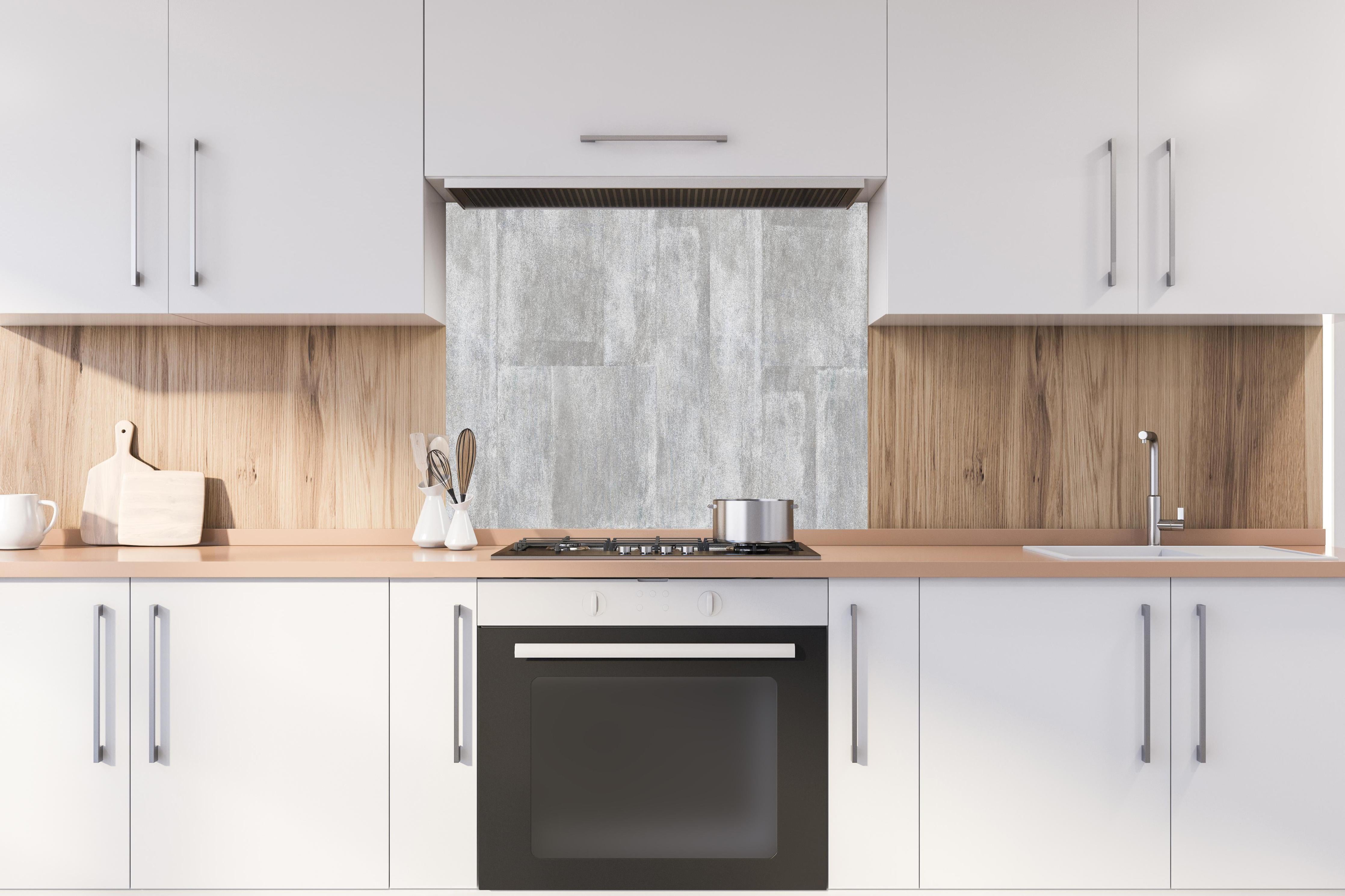 Spritzschutz - Grauweiße Betonblockwand Strukturiert hinter einem Cerankochfeld zwischen Holz-Kochutensilien