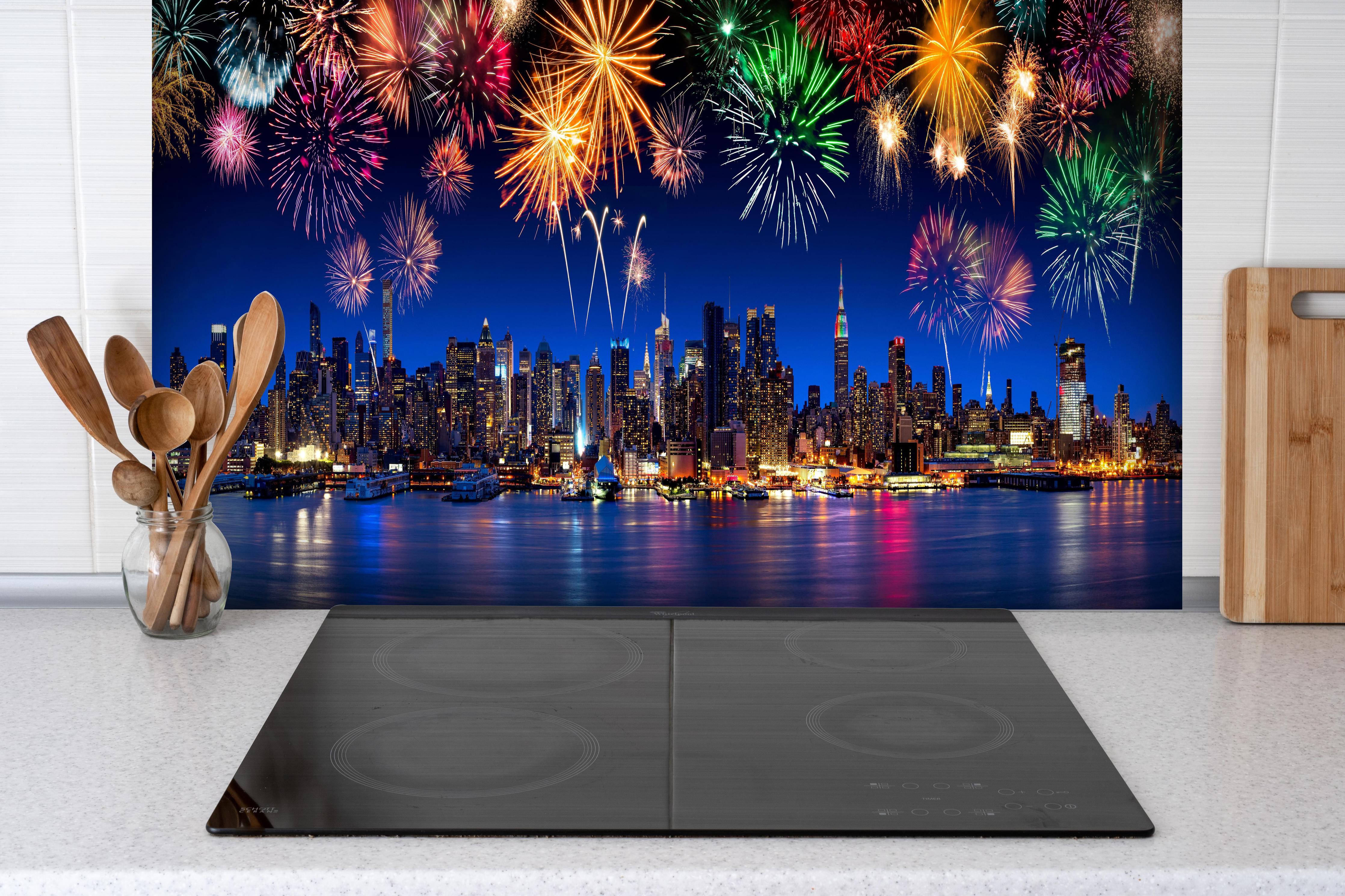 Spritzschutz - Großes Feuerwerk in New York hinter einem Cerankochfeld zwischen Holz-Kochutensilien