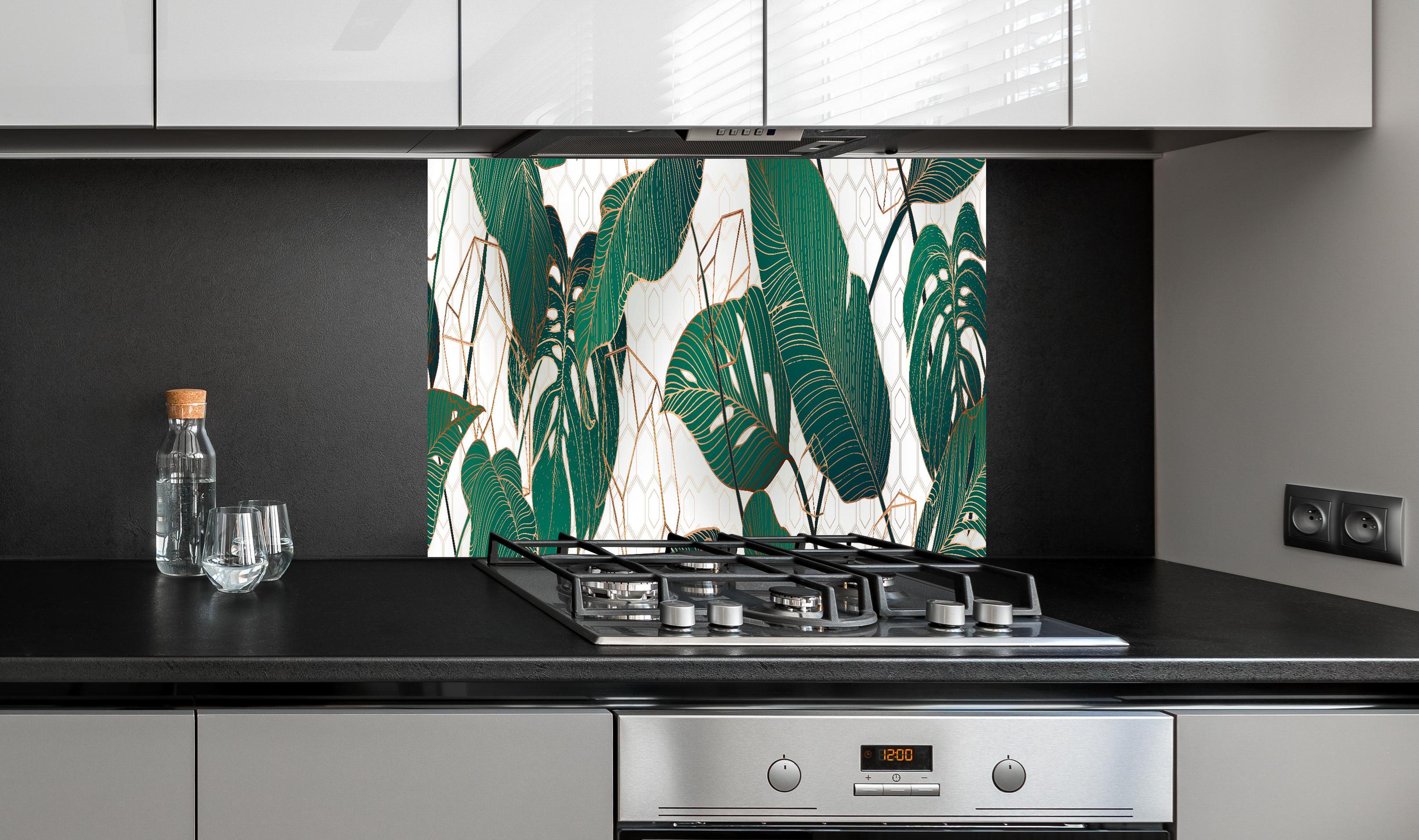 Spritzschutz - Grüne Blätter auf eleganter Tapete hinter einem Cerankochfeld zwischen Holz-Kochutensilien